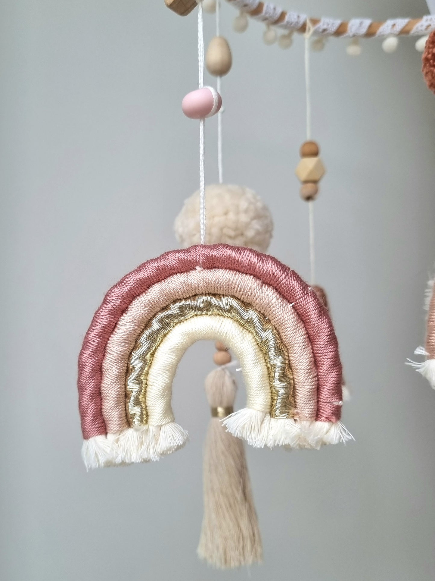 Selbstgemachtes Babymobile mit liebevoll handgefertigten Figuren und Formen, ideal für das Kinderbett oder den Kinderwagen. Durch die bunten Makrameebögen, fördert das Babymobile die visuelle und sensorische Entwicklung des Babys. Leicht und sicher aufzuhängen, schafft es eine beruhigende und kreative Umgebung für Ihr Kind.