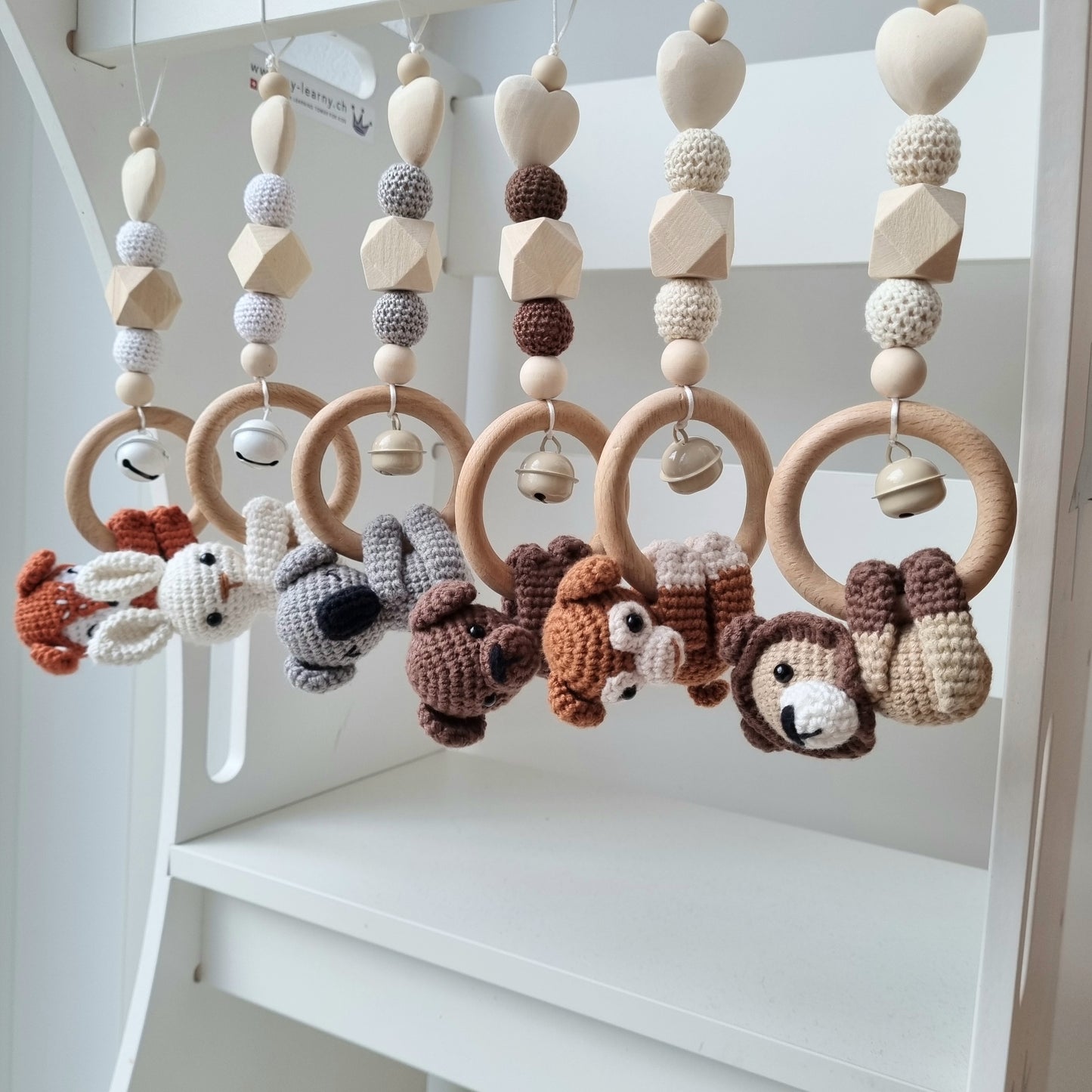 Ein handgefertigter Maxi-Cosi-Anhänger aus bunten Perlen, Häkeltier und Holzelementen, der unterwegs für Unterhaltung sorgt. Die verschiedenen Farben und Texturen machen das Reisen mit dem Baby nie langweilig. Ideal für Maxi-Cosi, Kinderwagen oder Bettchen.