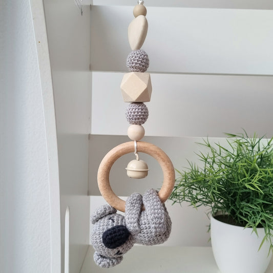 Ein handgefertigter Maxi-Cosi-Anhänger aus bunten Perlen, Häkeltier und Holzelementen, der unterwegs für Unterhaltung sorgt. Die verschiedenen Farben und Texturen machen das Reisen mit dem Baby nie langweilig. Ideal für Maxi-Cosi, Kinderwagen oder Bettchen.