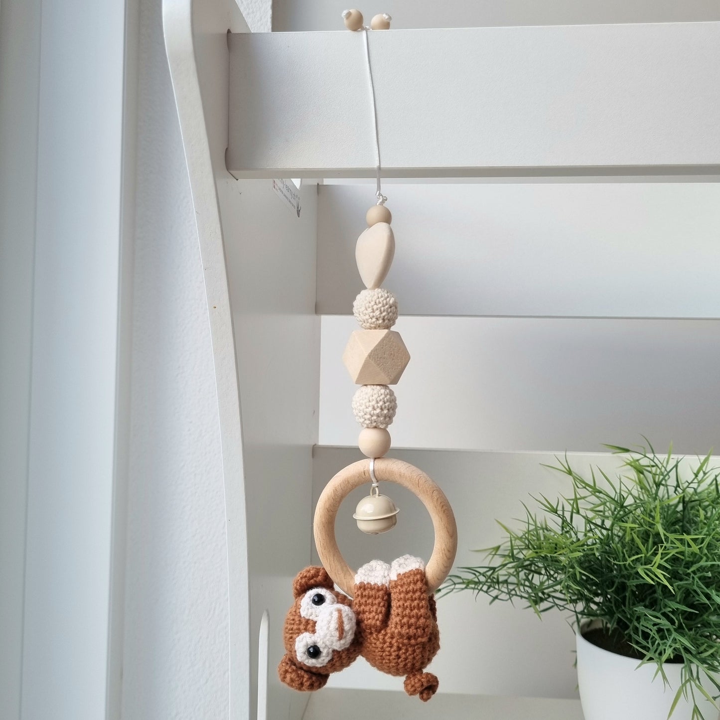 Ein handgefertigter Maxi-Cosi-Anhänger aus bunten Perlen, Häkeltier und Holzelementen, der unterwegs für Unterhaltung sorgt. Die verschiedenen Farben und Texturen machen das Reisen mit dem Baby nie langweilig. Ideal für Maxi-Cosi, Kinderwagen oder Bettchen.