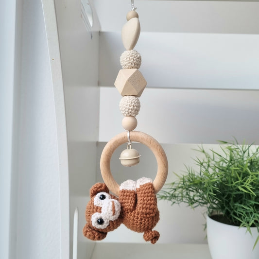 Ein handgefertigter Maxi-Cosi-Anhänger aus bunten Perlen, Häkeltier und Holzelementen, der unterwegs für Unterhaltung sorgt. Die verschiedenen Farben und Texturen machen das Reisen mit dem Baby nie langweilig. Ideal für Maxi-Cosi, Kinderwagen oder Bettchen.