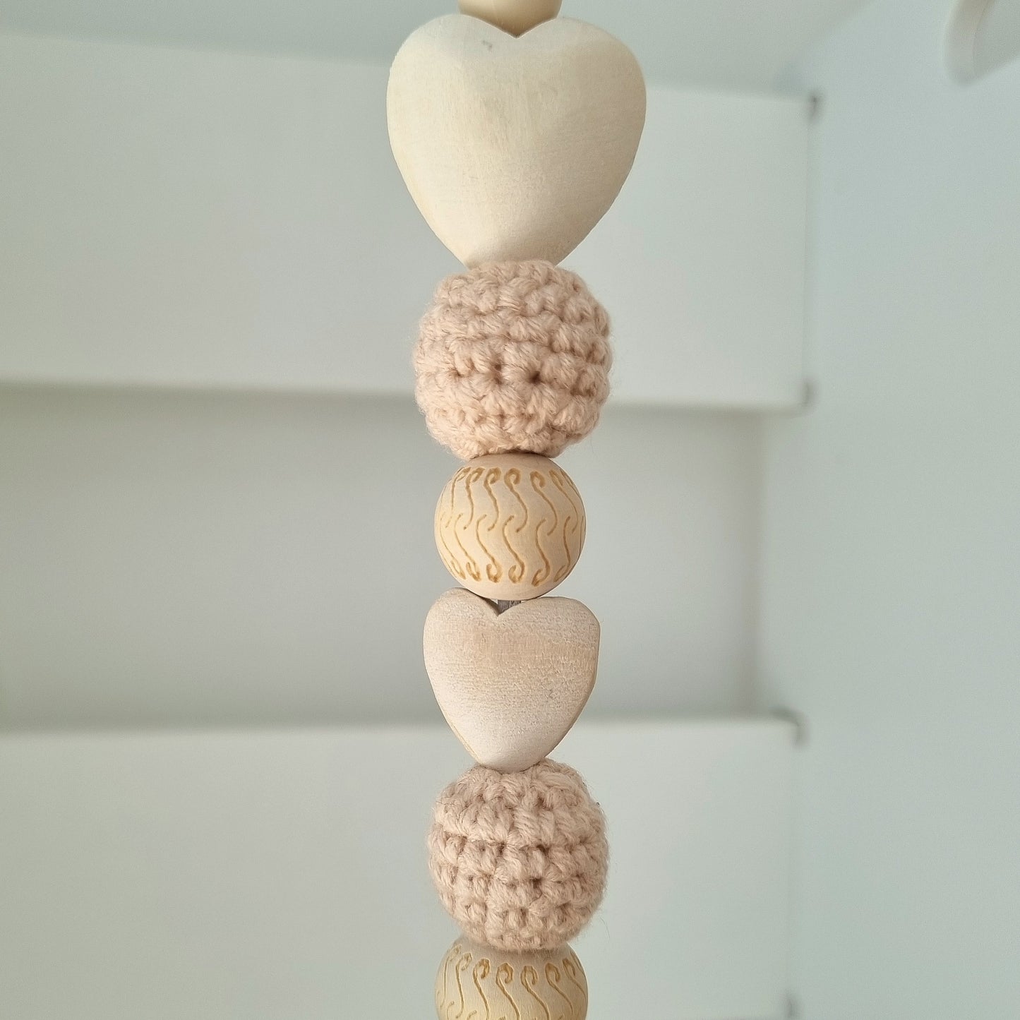 Ein handgefertigter Maxi-Cosi-Anhänger aus bunten Perlen, Häkeltier und Holzelementen, der unterwegs für Unterhaltung sorgt. Die verschiedenen Farben und Texturen machen das Reisen mit dem Baby nie langweilig. Ideal für Maxi-Cosi, Kinderwagen oder Bettchen.