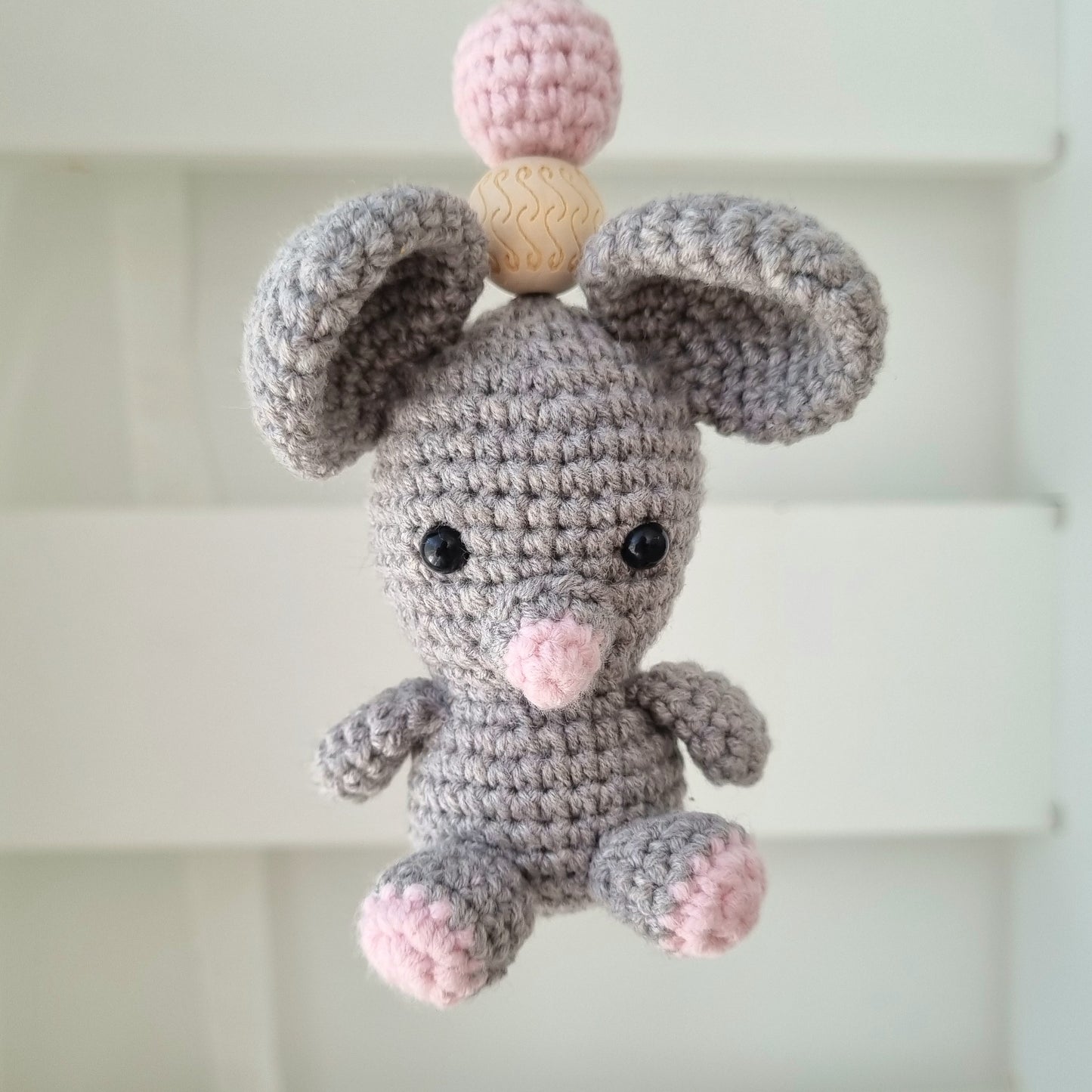 Ein handgefertigter Maxi-Cosi-Anhänger aus bunten Perlen, Häkeltier und Holzelementen, der unterwegs für Unterhaltung sorgt. Die verschiedenen Farben und Texturen machen das Reisen mit dem Baby nie langweilig. Ideal für Maxi-Cosi, Kinderwagen oder Bettchen.