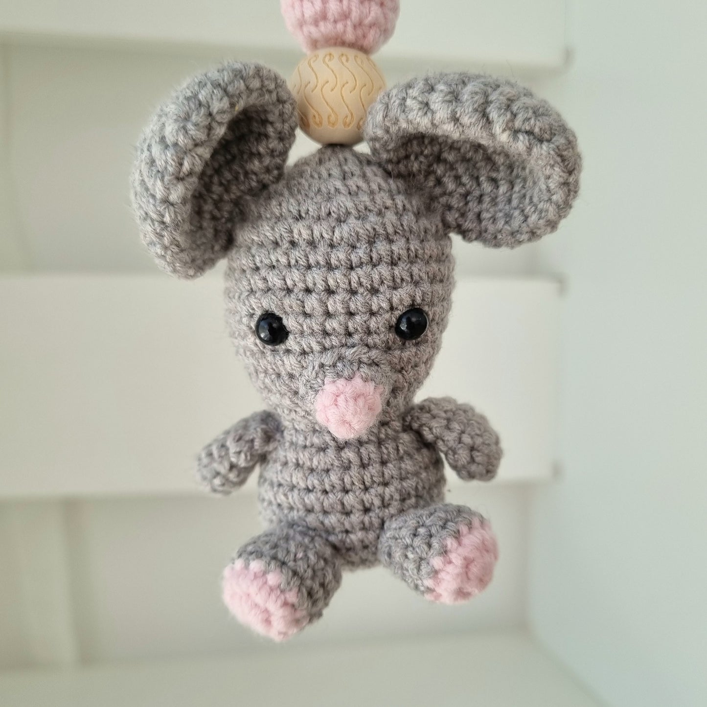 Ein handgefertigter Maxi-Cosi-Anhänger aus bunten Perlen, Häkeltier und Holzelementen, der unterwegs für Unterhaltung sorgt. Die verschiedenen Farben und Texturen machen das Reisen mit dem Baby nie langweilig. Ideal für Maxi-Cosi, Kinderwagen oder Bettchen.