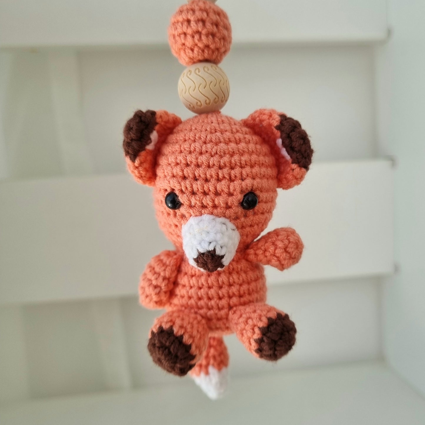 Ein handgefertigter Maxi-Cosi-Anhänger aus bunten Perlen, Häkeltier und Holzelementen, der unterwegs für Unterhaltung sorgt. Die verschiedenen Farben und Texturen machen das Reisen mit dem Baby nie langweilig. Ideal für Maxi-Cosi, Kinderwagen oder Bettchen.