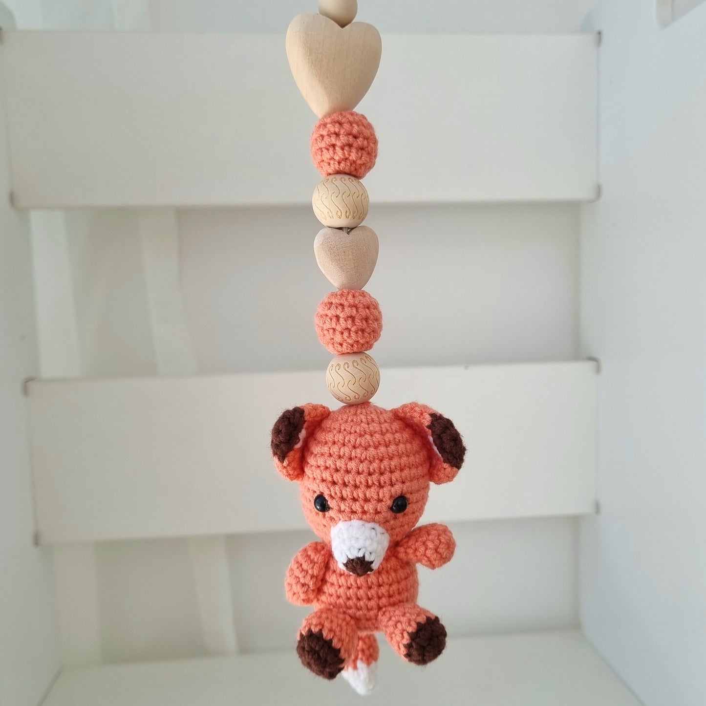 Ein handgefertigter Maxi-Cosi-Anhänger aus bunten Perlen, Häkeltier und Holzelementen, der unterwegs für Unterhaltung sorgt. Die verschiedenen Farben und Texturen machen das Reisen mit dem Baby nie langweilig. Ideal für Maxi-Cosi, Kinderwagen oder Bettchen.