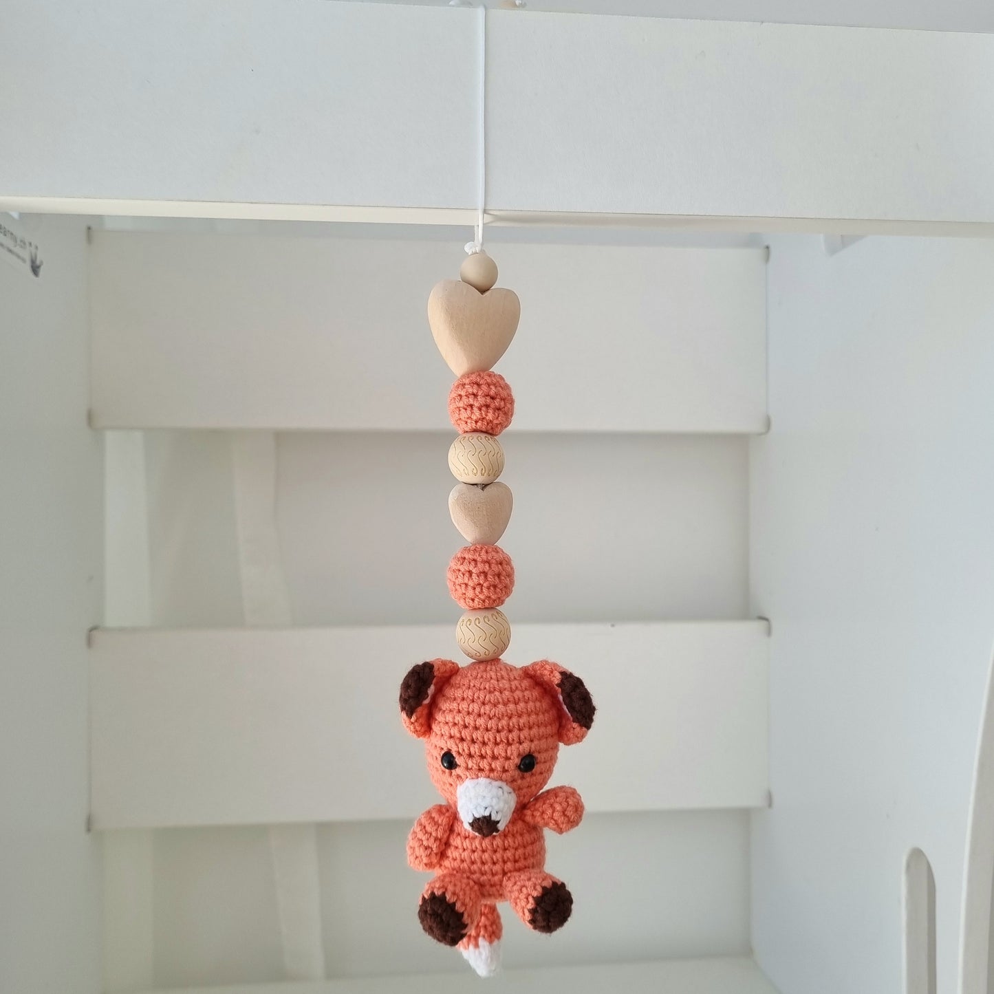 Ein handgefertigter Maxi-Cosi-Anhänger aus bunten Perlen, Häkeltier und Holzelementen, der unterwegs für Unterhaltung sorgt. Die verschiedenen Farben und Texturen machen das Reisen mit dem Baby nie langweilig. Ideal für Maxi-Cosi, Kinderwagen oder Bettchen.