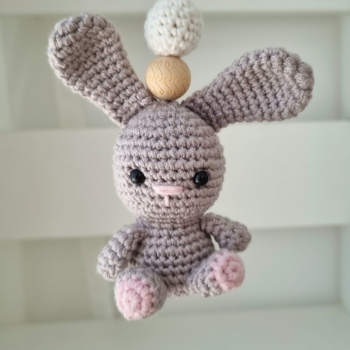Ein handgefertigter Maxi-Cosi-Anhänger aus bunten Perlen, Häkeltier und Holzelementen, der unterwegs für Unterhaltung sorgt. Die verschiedenen Farben und Texturen machen das Reisen mit dem Baby nie langweilig. Ideal für Maxi-Cosi, Kinderwagen oder Bettchen.