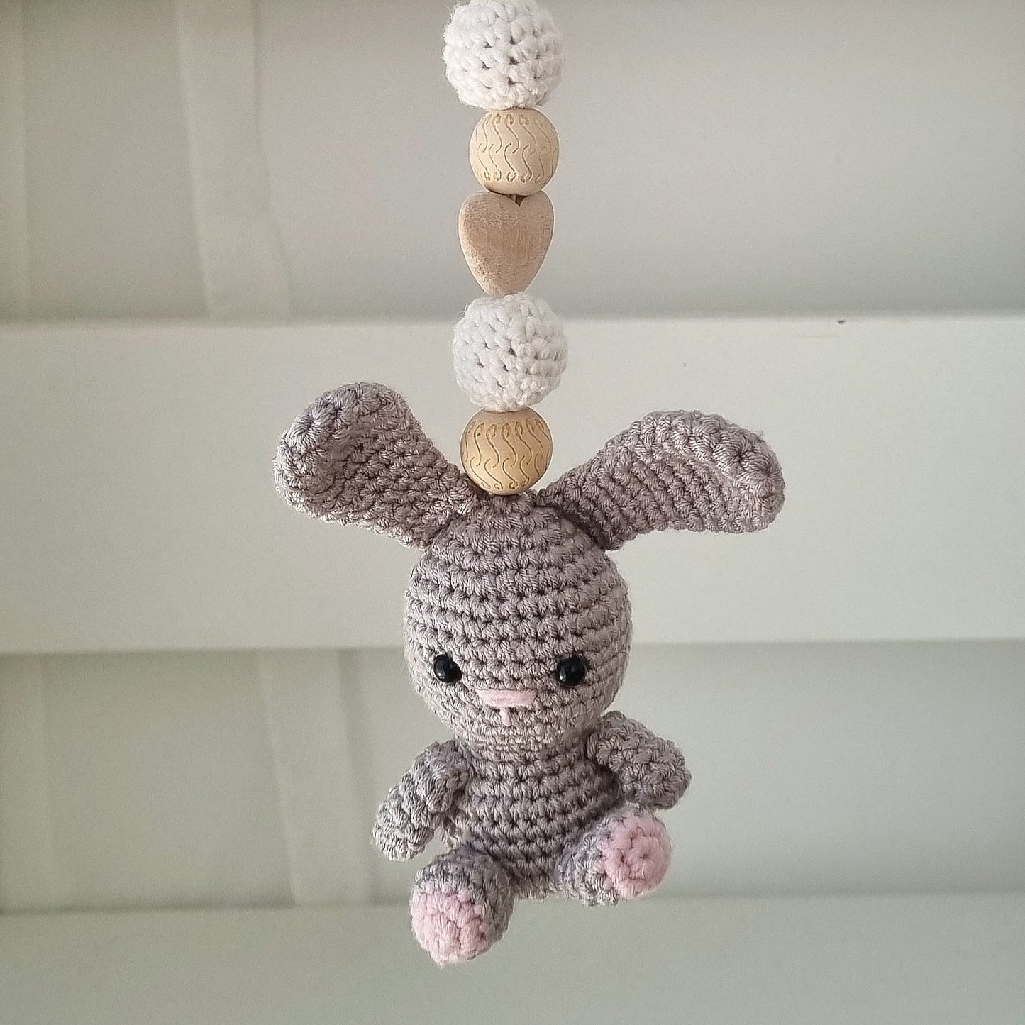 Ein handgefertigter Maxi-Cosi-Anhänger aus bunten Perlen, Häkeltier und Holzelementen, der unterwegs für Unterhaltung sorgt. Die verschiedenen Farben und Texturen machen das Reisen mit dem Baby nie langweilig. Ideal für Maxi-Cosi, Kinderwagen oder Bettchen.
