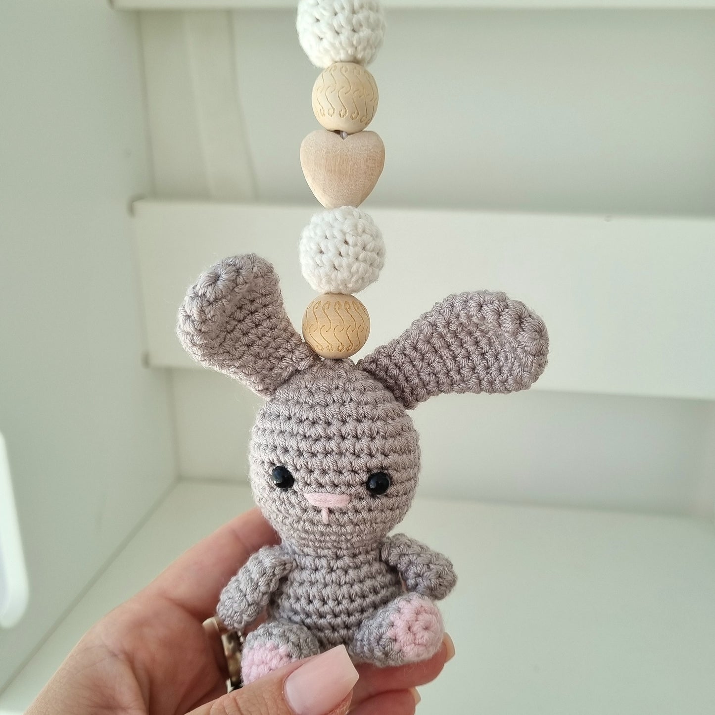 Ein handgefertigter Maxi-Cosi-Anhänger aus bunten Perlen, Häkeltier und Holzelementen, der unterwegs für Unterhaltung sorgt. Die verschiedenen Farben und Texturen machen das Reisen mit dem Baby nie langweilig. Ideal für Maxi-Cosi, Kinderwagen oder Bettchen.