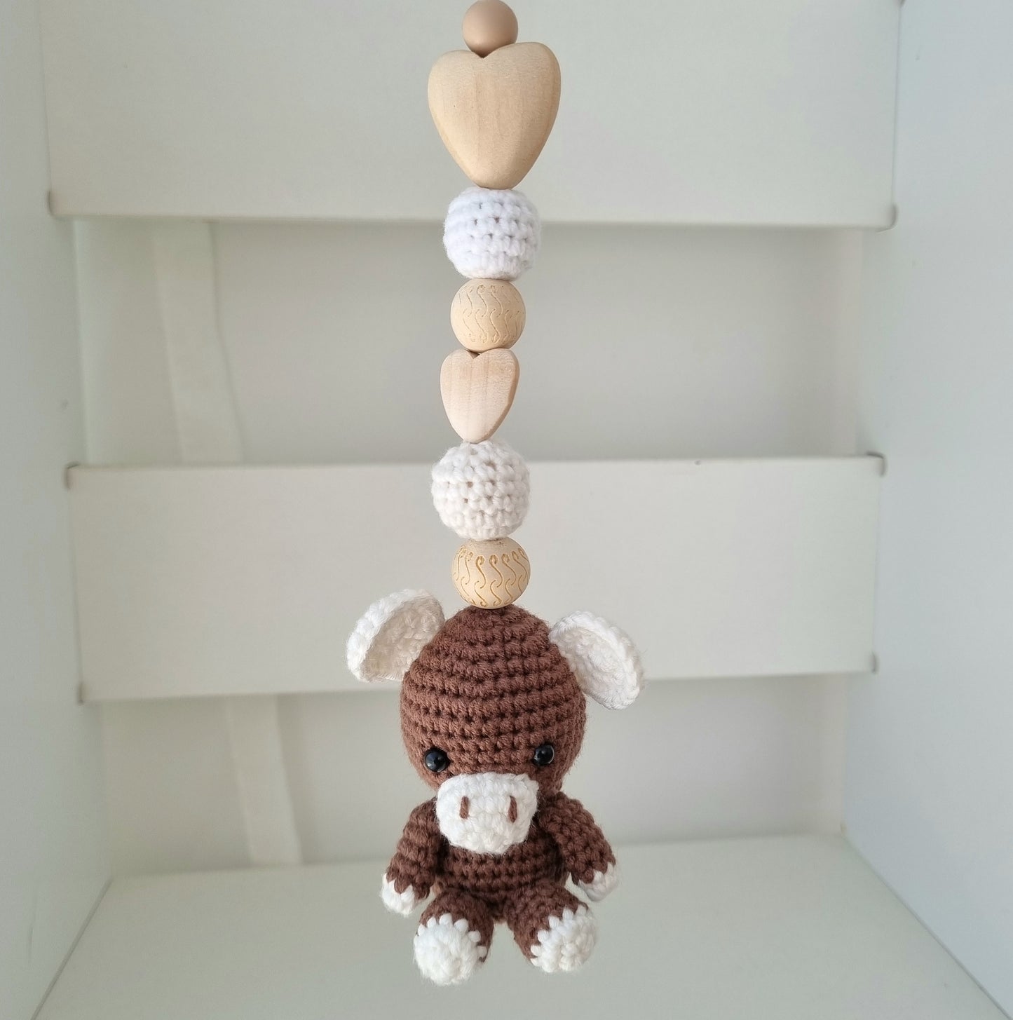 Ein handgefertigter Maxi-Cosi-Anhänger aus bunten Perlen, Häkeltier und Holzelementen, der unterwegs für Unterhaltung sorgt. Die verschiedenen Farben und Texturen machen das Reisen mit dem Baby nie langweilig. Ideal für Maxi-Cosi, Kinderwagen oder Bettchen.