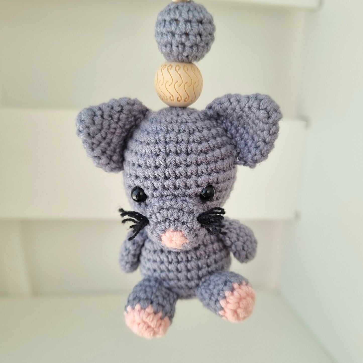 Ein handgefertigter Maxi-Cosi-Anhänger aus bunten Perlen, Häkeltier und Holzelementen, der unterwegs für Unterhaltung sorgt. Die verschiedenen Farben und Texturen machen das Reisen mit dem Baby nie langweilig. Ideal für Maxi-Cosi, Kinderwagen oder Bettchen.