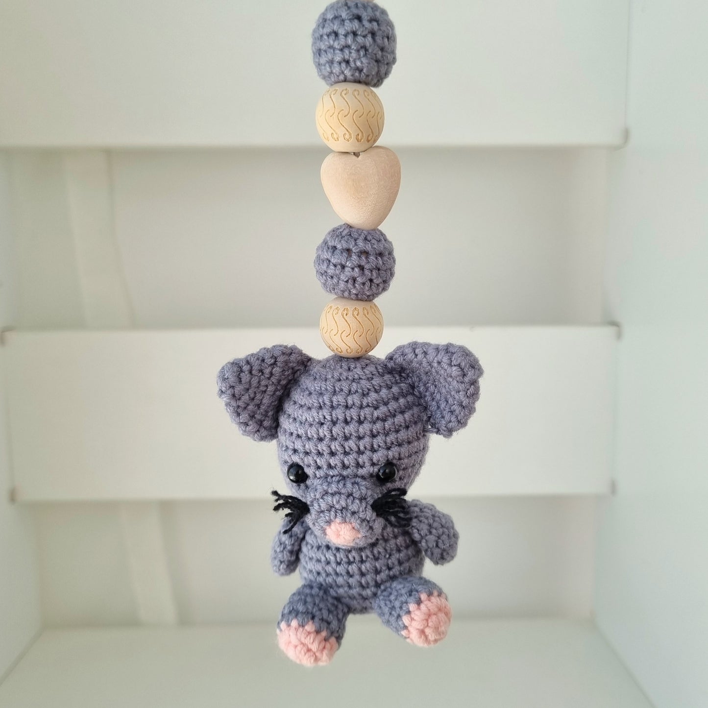 Ein handgefertigter Maxi-Cosi-Anhänger aus bunten Perlen, Häkeltier und Holzelementen, der unterwegs für Unterhaltung sorgt. Die verschiedenen Farben und Texturen machen das Reisen mit dem Baby nie langweilig. Ideal für Maxi-Cosi, Kinderwagen oder Bettchen.