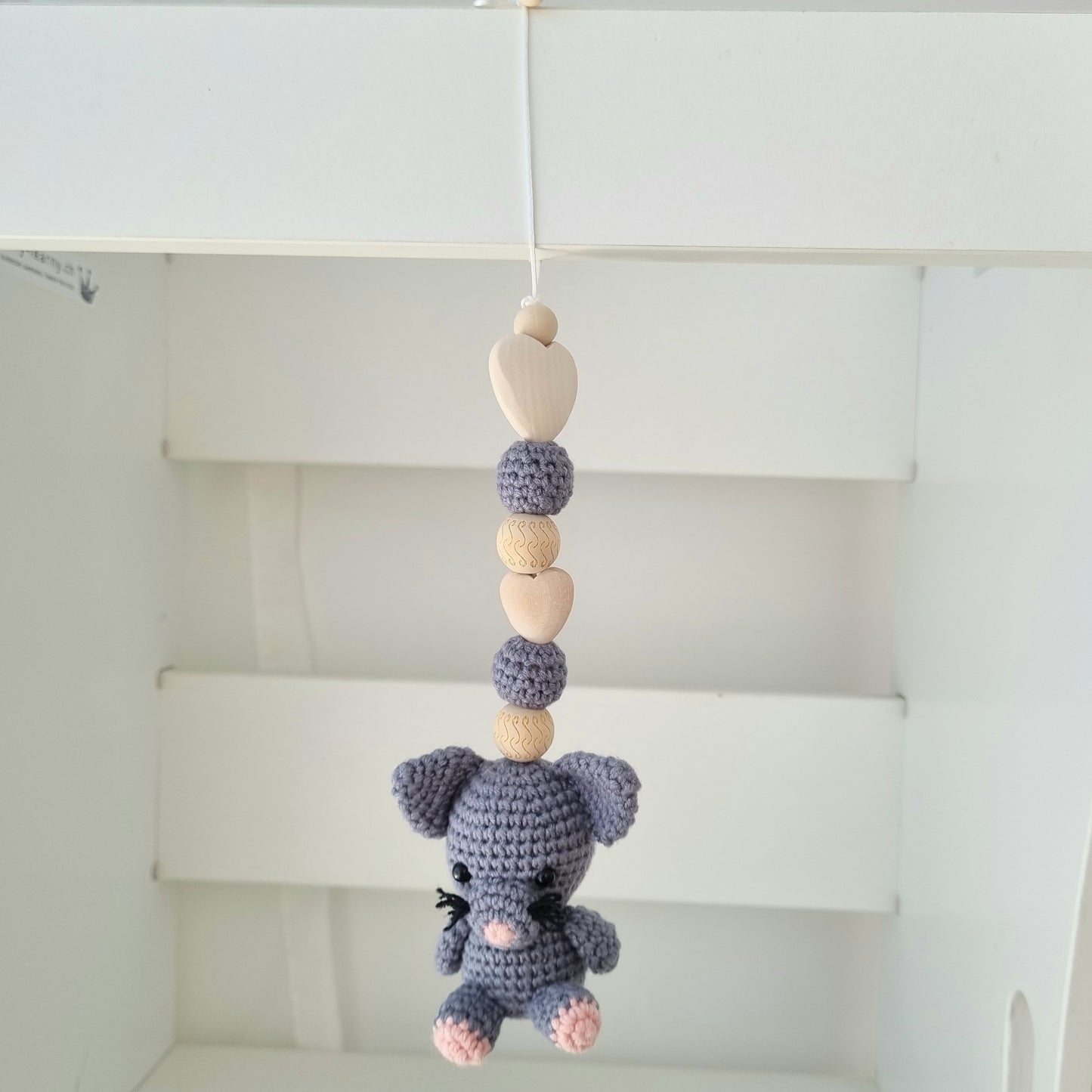 Ein handgefertigter Maxi-Cosi-Anhänger aus bunten Perlen, Häkeltier und Holzelementen, der unterwegs für Unterhaltung sorgt. Die verschiedenen Farben und Texturen machen das Reisen mit dem Baby nie langweilig. Ideal für Maxi-Cosi, Kinderwagen oder Bettchen.