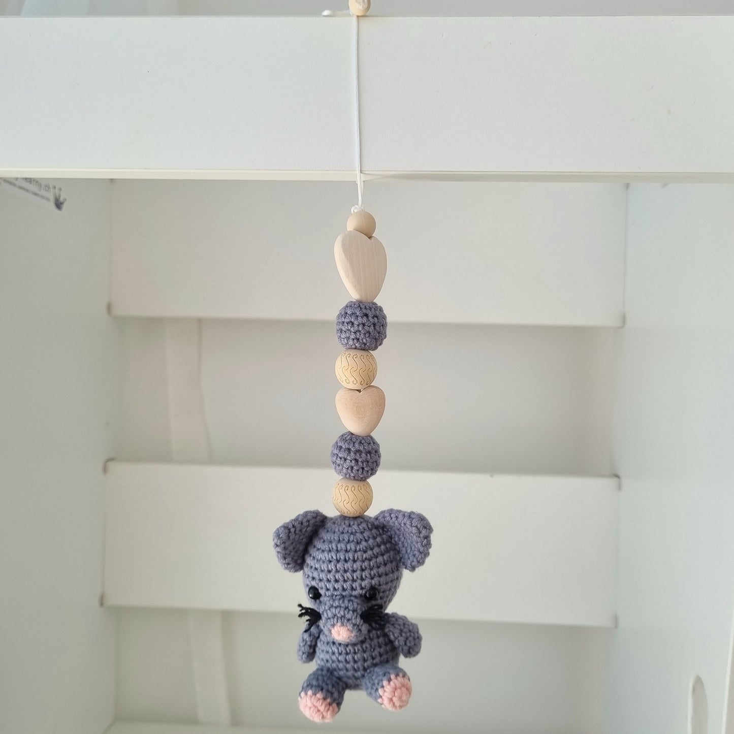 Ein handgefertigter Maxi-Cosi-Anhänger aus bunten Perlen, Häkeltier und Holzelementen, der unterwegs für Unterhaltung sorgt. Die verschiedenen Farben und Texturen machen das Reisen mit dem Baby nie langweilig. Ideal für Maxi-Cosi, Kinderwagen oder Bettchen.