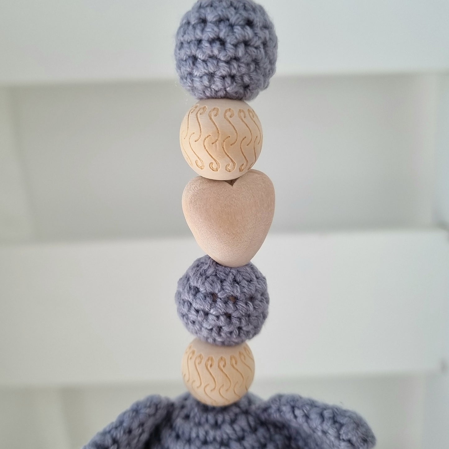 Ein handgefertigter Maxi-Cosi-Anhänger aus bunten Perlen, Häkeltier und Holzelementen, der unterwegs für Unterhaltung sorgt. Die verschiedenen Farben und Texturen machen das Reisen mit dem Baby nie langweilig. Ideal für Maxi-Cosi, Kinderwagen oder Bettchen.