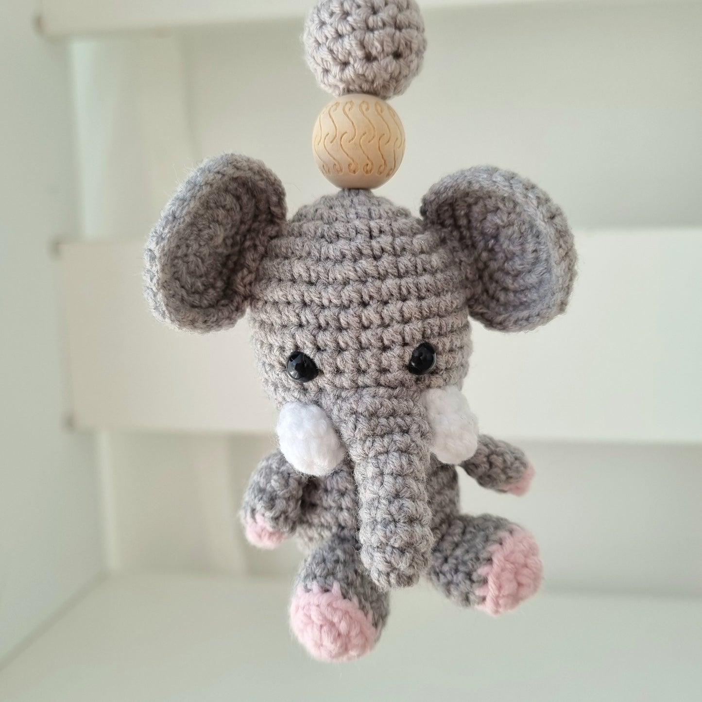 Ein handgefertigter Maxi-Cosi-Anhänger aus bunten Perlen, Häkeltier und Holzelementen, der unterwegs für Unterhaltung sorgt. Die verschiedenen Farben und Texturen machen das Reisen mit dem Baby nie langweilig. Ideal für Maxi-Cosi, Kinderwagen oder Bettchen.