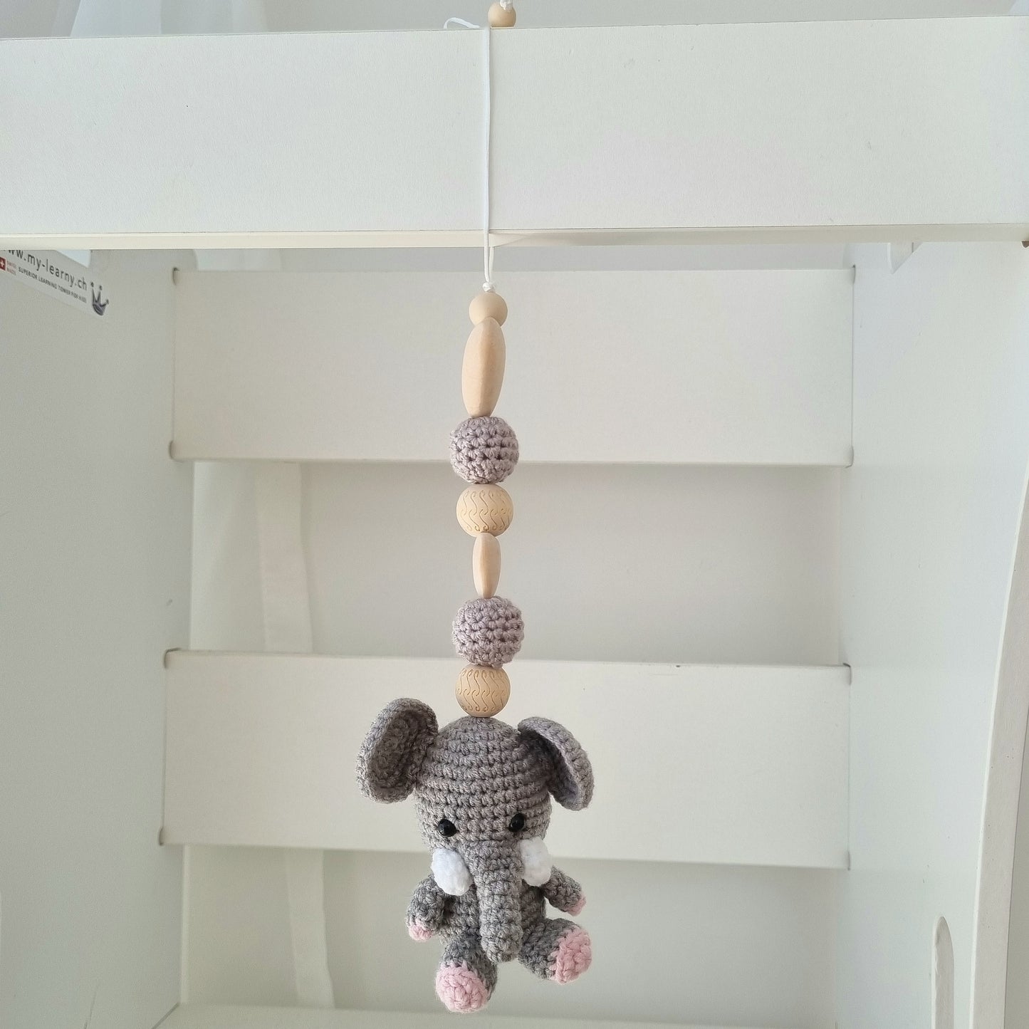 Ein handgefertigter Maxi-Cosi-Anhänger aus bunten Perlen, Häkeltier und Holzelementen, der unterwegs für Unterhaltung sorgt. Die verschiedenen Farben und Texturen machen das Reisen mit dem Baby nie langweilig. Ideal für Maxi-Cosi, Kinderwagen oder Bettchen.