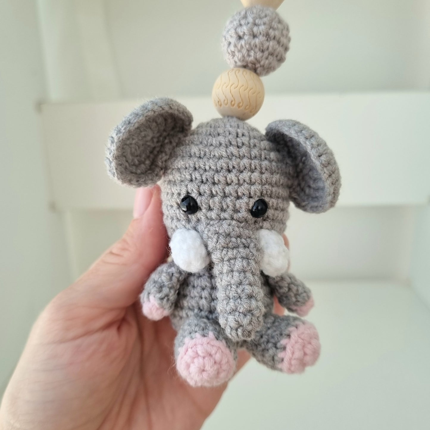 Ein handgefertigter Maxi-Cosi-Anhänger aus bunten Perlen, Häkeltier und Holzelementen, der unterwegs für Unterhaltung sorgt. Die verschiedenen Farben und Texturen machen das Reisen mit dem Baby nie langweilig. Ideal für Maxi-Cosi, Kinderwagen oder Bettchen.