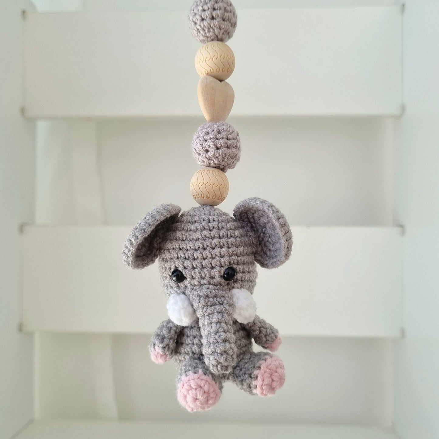 Ein handgefertigter Maxi-Cosi-Anhänger aus bunten Perlen, Häkeltier und Holzelementen, der unterwegs für Unterhaltung sorgt. Die verschiedenen Farben und Texturen machen das Reisen mit dem Baby nie langweilig. Ideal für Maxi-Cosi, Kinderwagen oder Bettchen.