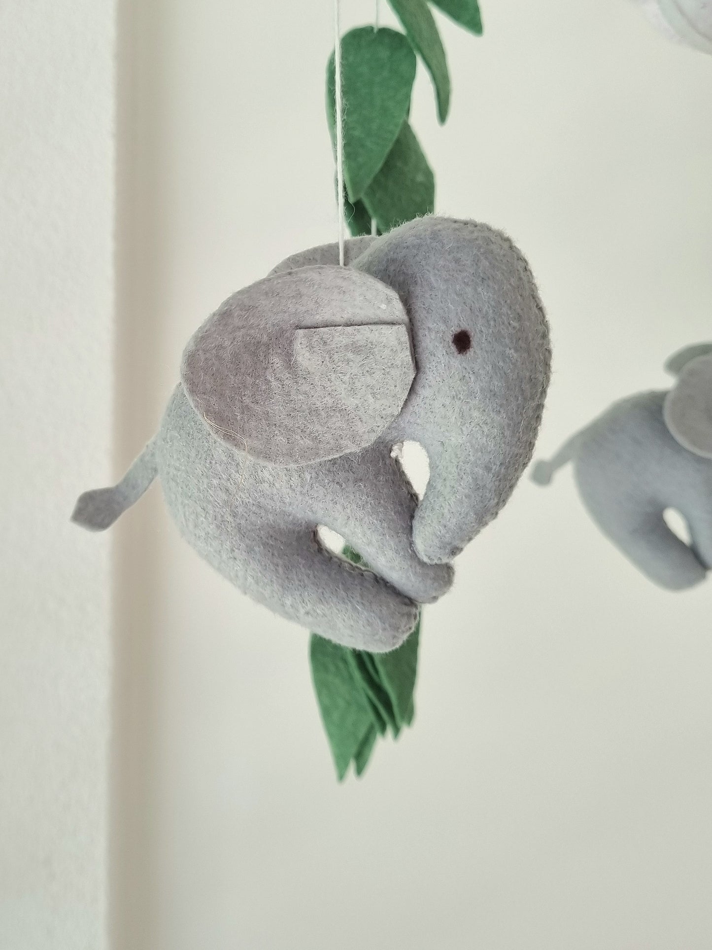 Selbstgemachtes Filzmobile mit liebevoll handgefertigten Figuren und Formen, ideal für das Babybett oder den Kinderwagen. Hergestellt aus weichem, hochwertigem Filz in bunten Farben, fördert es die visuelle und sensorische Entwicklung des Babys. Leicht und sicher aufzuhängen im Babyzimmer, schafft es eine beruhigende und kreative Umgebung für Ihr Kind.