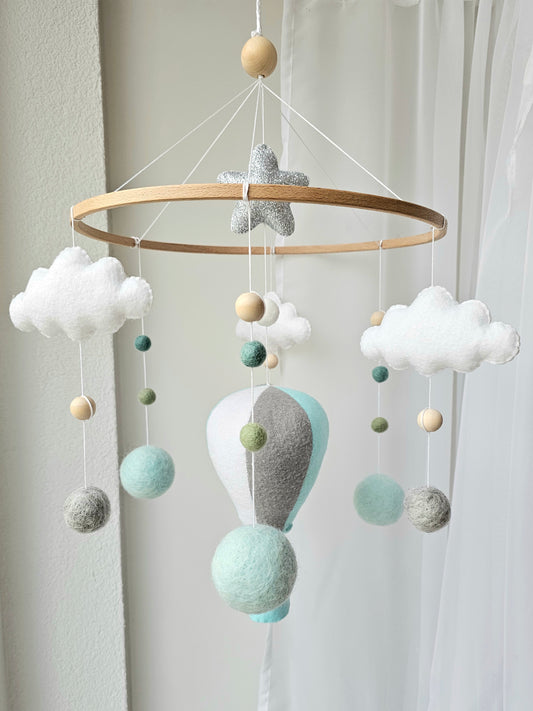 Selbstgemachtes Babymobile mit liebevoll handgefertigten Figuren und Formen, ideal für das Kinderbett oder den Kinderwagen. Hergestellt aus weichem, hochwertigem Filz in bunten Farben, fördert das Babymobile die visuelle und sensorische Entwicklung des Babys. Leicht und sicher aufzuhängen, schafft es eine beruhigende und kreative Umgebung für Ihr Kind.