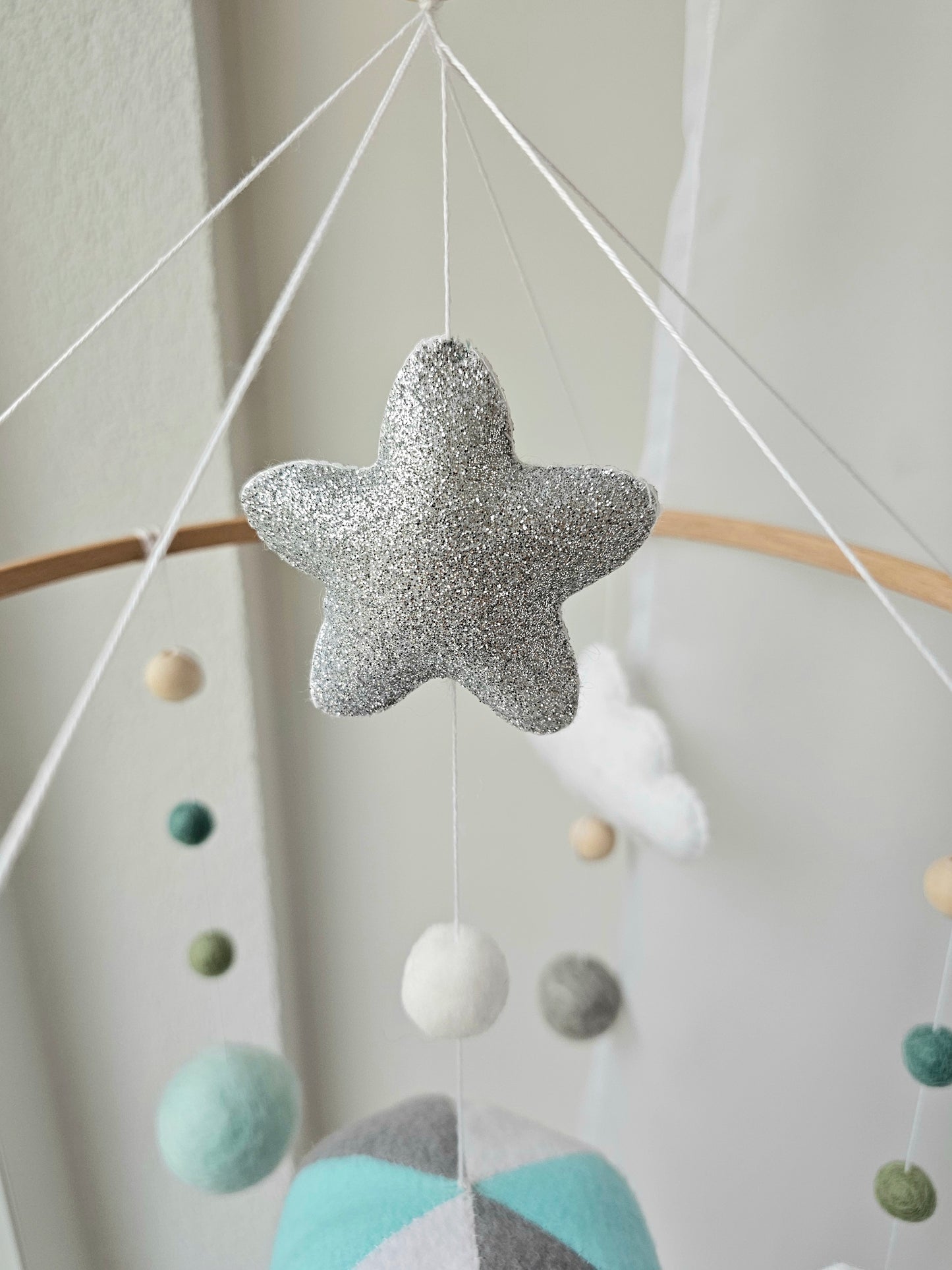 Selbstgemachtes Babymobile mit liebevoll handgefertigten Figuren und Formen, ideal für das Kinderbett oder den Kinderwagen. Hergestellt aus weichem, hochwertigem Filz in bunten Farben, fördert das Babymobile die visuelle und sensorische Entwicklung des Babys. Leicht und sicher aufzuhängen, schafft es eine beruhigende und kreative Umgebung für Ihr Kind.