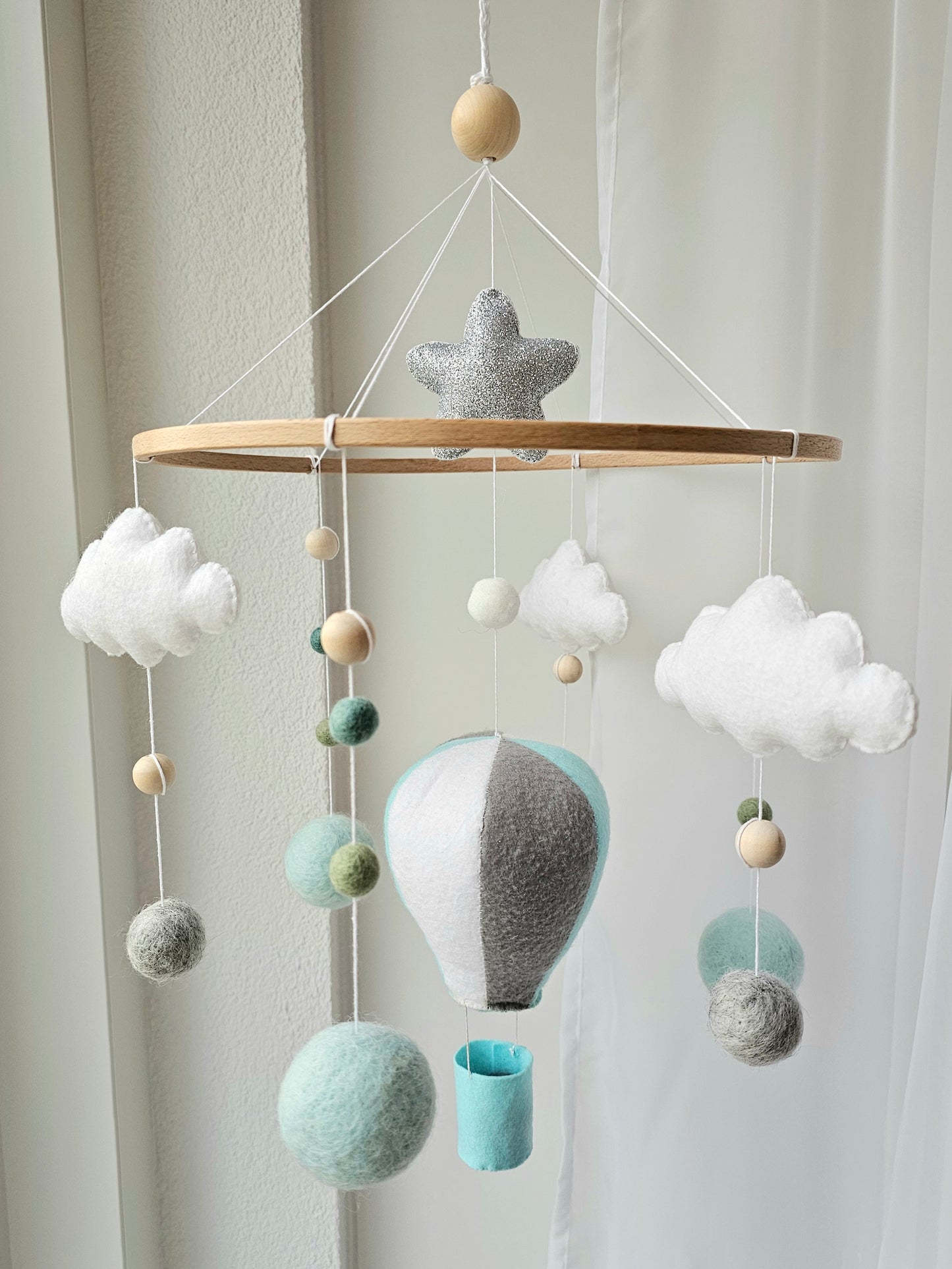 Selbstgemachtes Babymobile mit liebevoll handgefertigten Figuren und Formen, ideal für das Kinderbett oder den Kinderwagen. Hergestellt aus weichem, hochwertigem Filz in bunten Farben, fördert das Babymobile die visuelle und sensorische Entwicklung des Babys. Leicht und sicher aufzuhängen, schafft es eine beruhigende und kreative Umgebung für Ihr Kind.