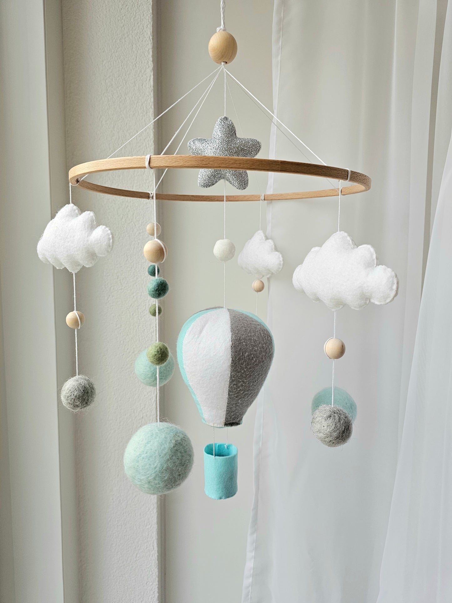 Selbstgemachtes Babymobile mit liebevoll handgefertigten Figuren und Formen, ideal für das Kinderbett oder den Kinderwagen. Hergestellt aus weichem, hochwertigem Filz in bunten Farben, fördert das Babymobile die visuelle und sensorische Entwicklung des Babys. Leicht und sicher aufzuhängen, schafft es eine beruhigende und kreative Umgebung für Ihr Kind.