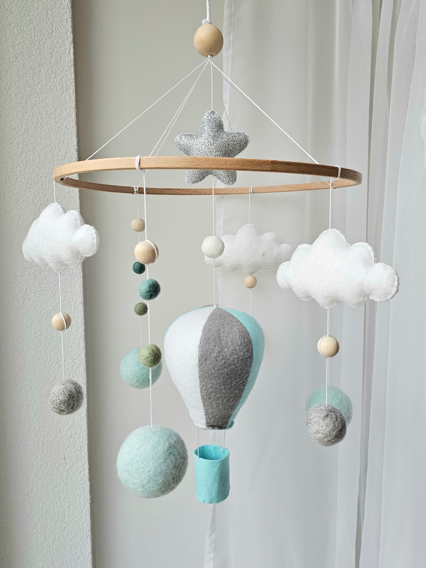 Selbstgemachtes Babymobile mit liebevoll handgefertigten Figuren und Formen, ideal für das Kinderbett oder den Kinderwagen. Hergestellt aus weichem, hochwertigem Filz in bunten Farben, fördert das Babymobile die visuelle und sensorische Entwicklung des Babys. Leicht und sicher aufzuhängen, schafft es eine beruhigende und kreative Umgebung für Ihr Kind.