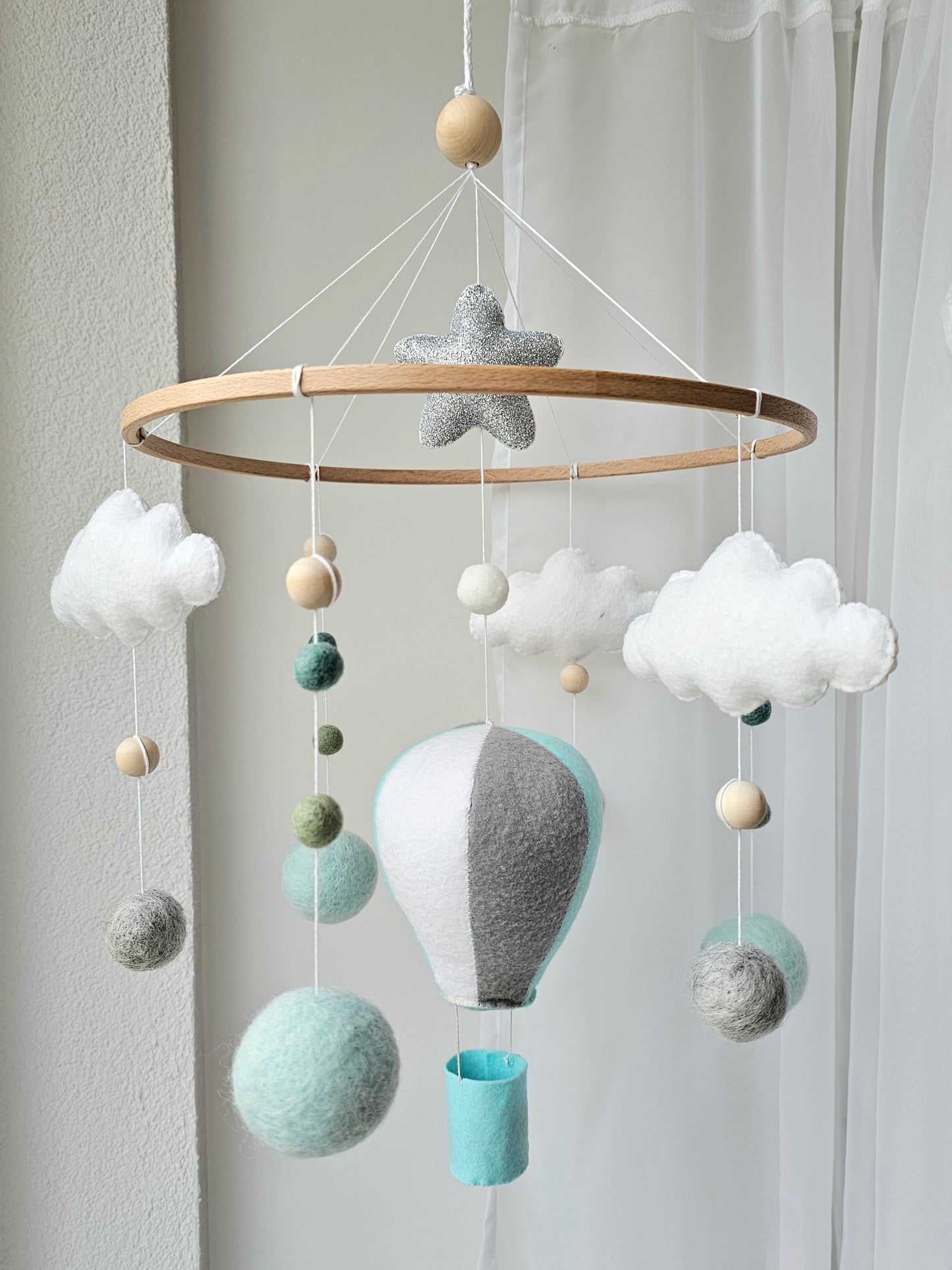 Selbstgemachtes Babymobile mit liebevoll handgefertigten Figuren und Formen, ideal für das Kinderbett oder den Kinderwagen. Hergestellt aus weichem, hochwertigem Filz in bunten Farben, fördert das Babymobile die visuelle und sensorische Entwicklung des Babys. Leicht und sicher aufzuhängen, schafft es eine beruhigende und kreative Umgebung für Ihr Kind.