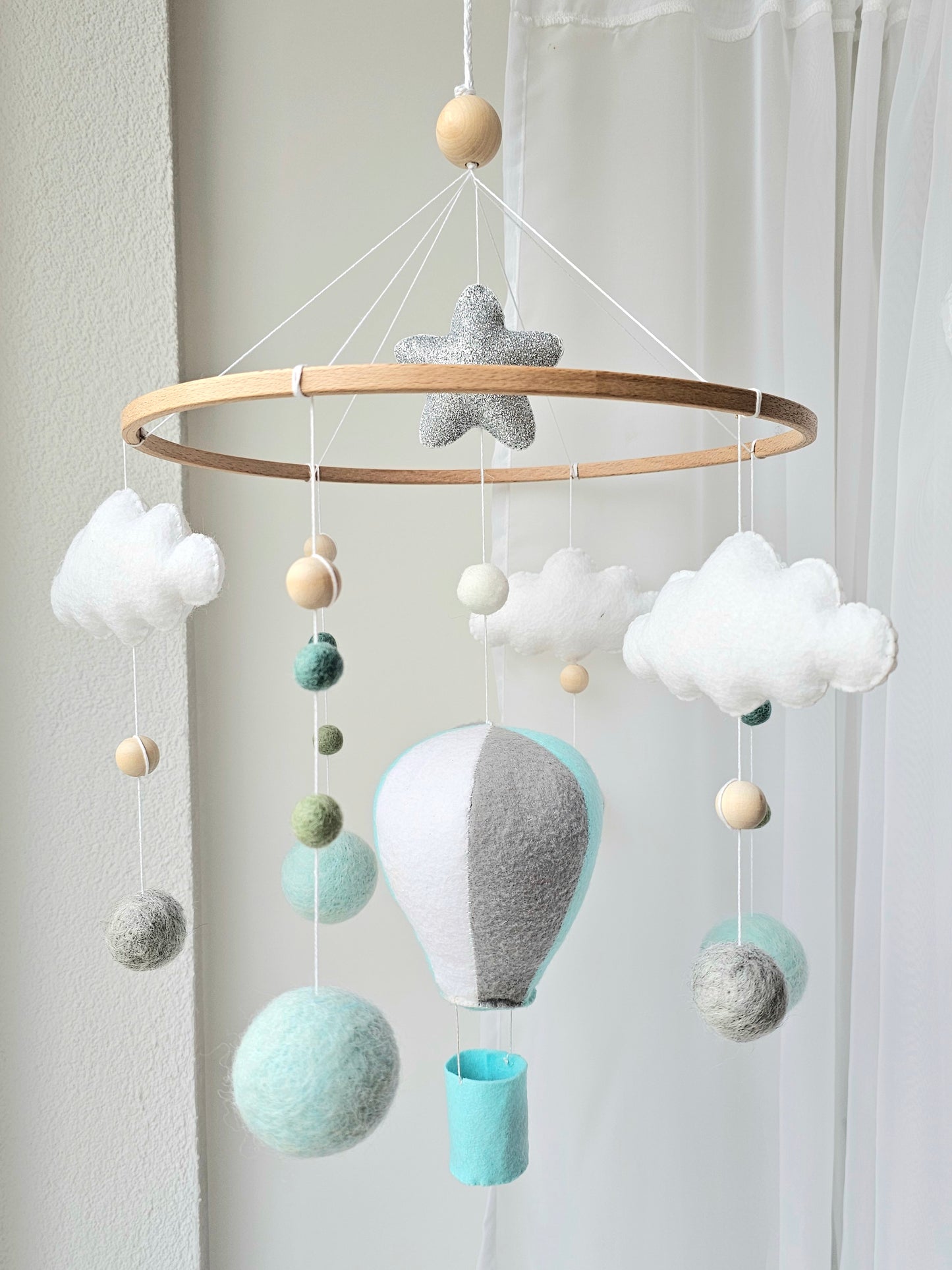 Selbstgemachtes Babymobile mit liebevoll handgefertigten Figuren und Formen, ideal für das Kinderbett oder den Kinderwagen. Hergestellt aus weichem, hochwertigem Filz in bunten Farben, fördert das Babymobile die visuelle und sensorische Entwicklung des Babys. Leicht und sicher aufzuhängen, schafft es eine beruhigende und kreative Umgebung für Ihr Kind.