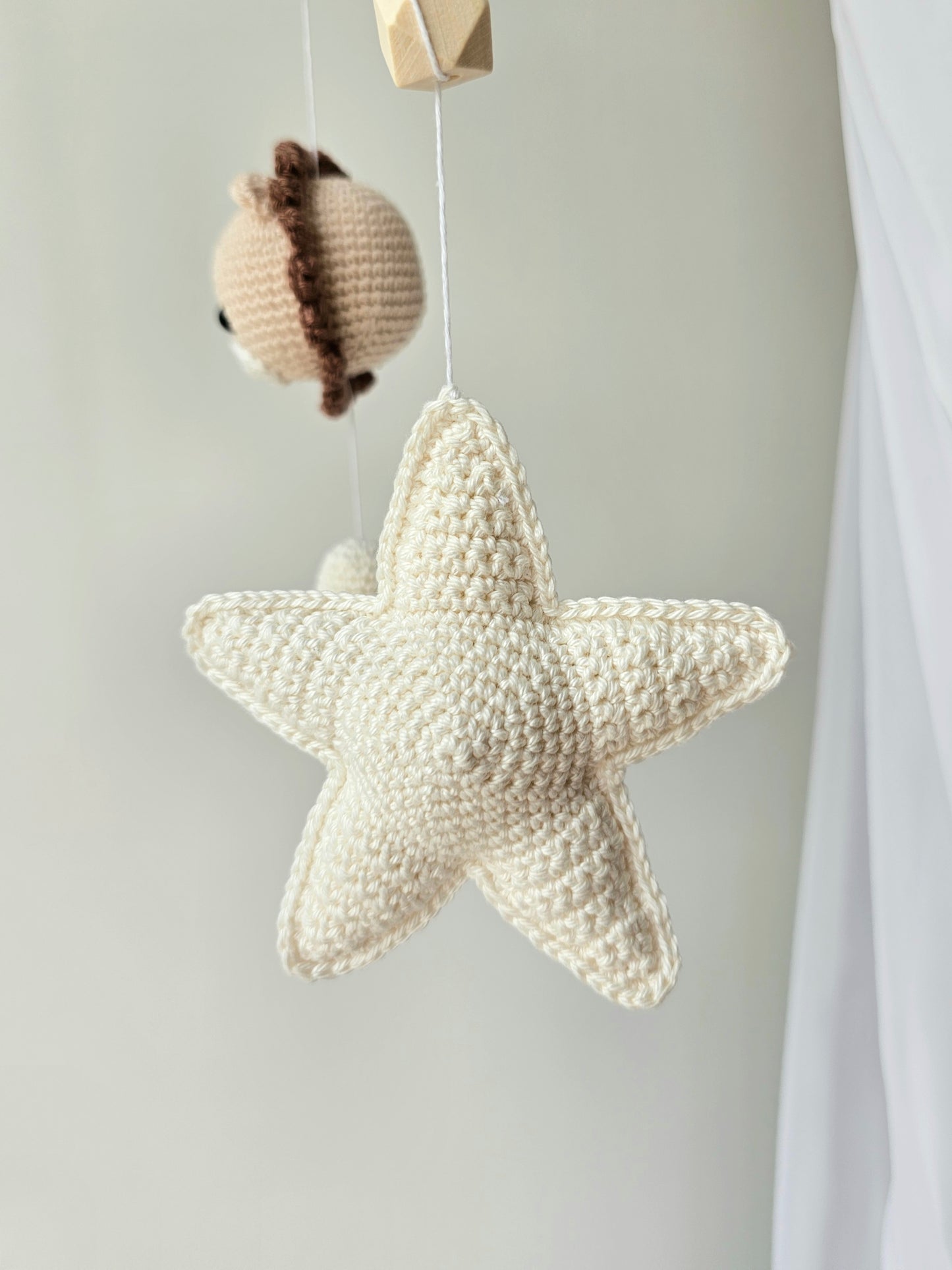 Selbstgemachtes Babymobile mit liebevoll von Hand gehäkelten Figuren und Formen, ideal für das Kinderbett oder den Kinderwagen. Hergestellt aus weichem, hochwertigem Filz in bunten Farben, fördert das Babymobile die visuelle und sensorische Entwicklung des Babys. Leicht und sicher aufzuhängen, schafft es eine beruhigende und kreative Umgebung für Ihr Kind.