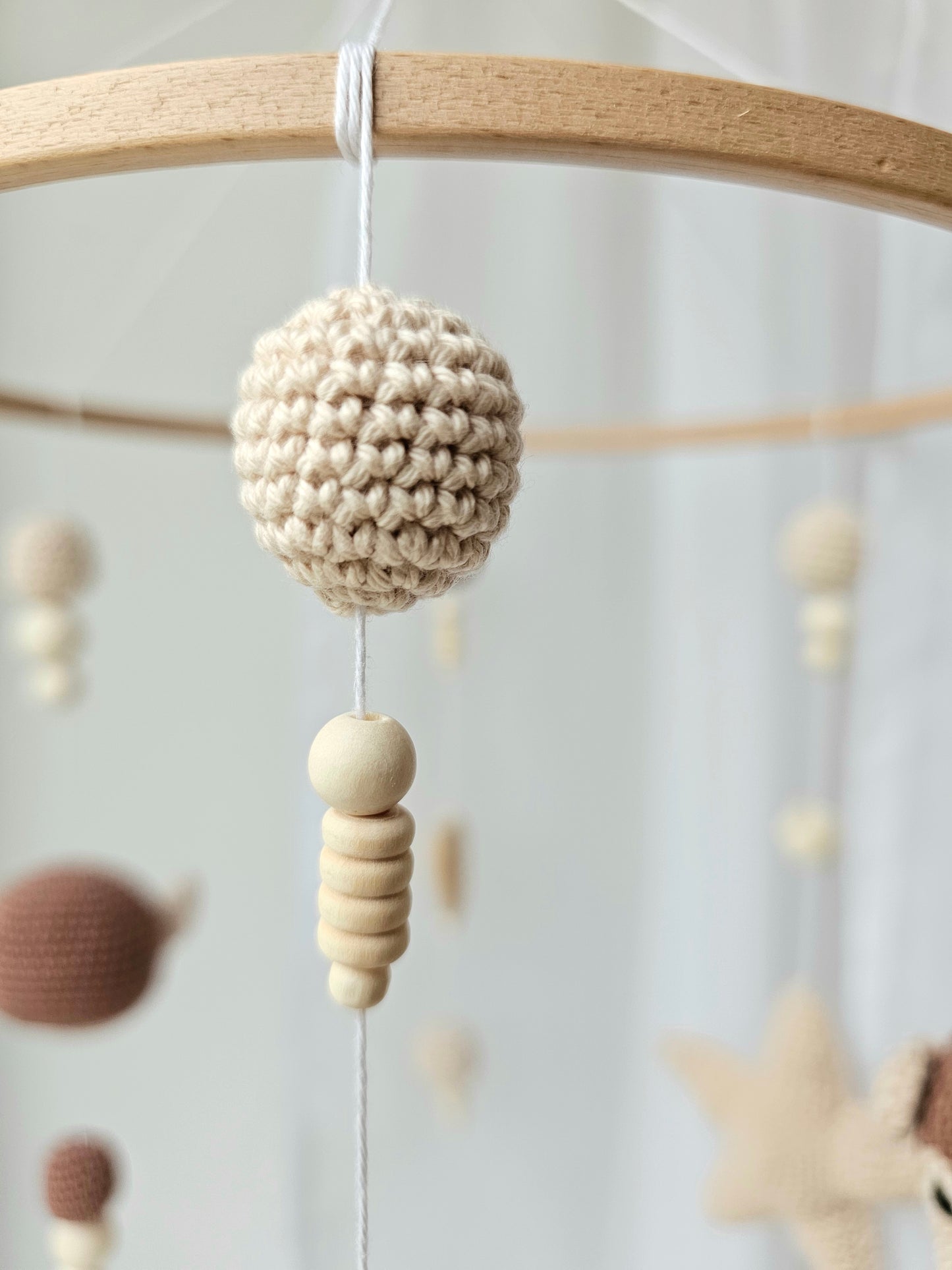Selbstgemachtes Babymobile mit liebevoll von Hand gehäkelten Figuren und Formen, ideal für das Kinderbett oder den Kinderwagen. Hergestellt aus weichem, hochwertigem Filz in bunten Farben, fördert das Babymobile die visuelle und sensorische Entwicklung des Babys. Leicht und sicher aufzuhängen, schafft es eine beruhigende und kreative Umgebung für Ihr Kind.