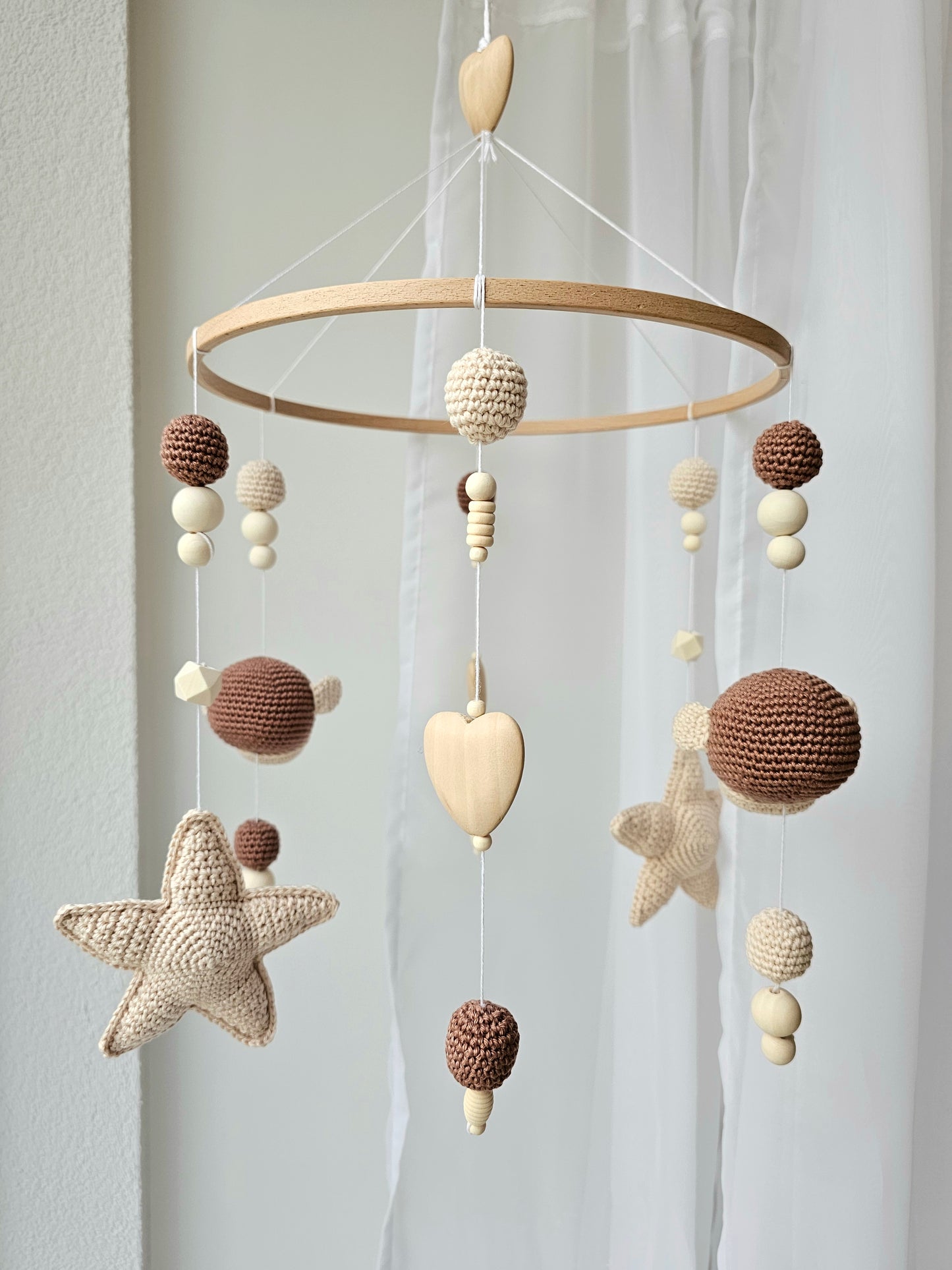 Selbstgemachtes Babymobile mit liebevoll von Hand gehäkelten Figuren und Formen, ideal für das Kinderbett oder den Kinderwagen. Hergestellt aus weichem, hochwertigem Filz in bunten Farben, fördert das Babymobile die visuelle und sensorische Entwicklung des Babys. Leicht und sicher aufzuhängen, schafft es eine beruhigende und kreative Umgebung für Ihr Kind.