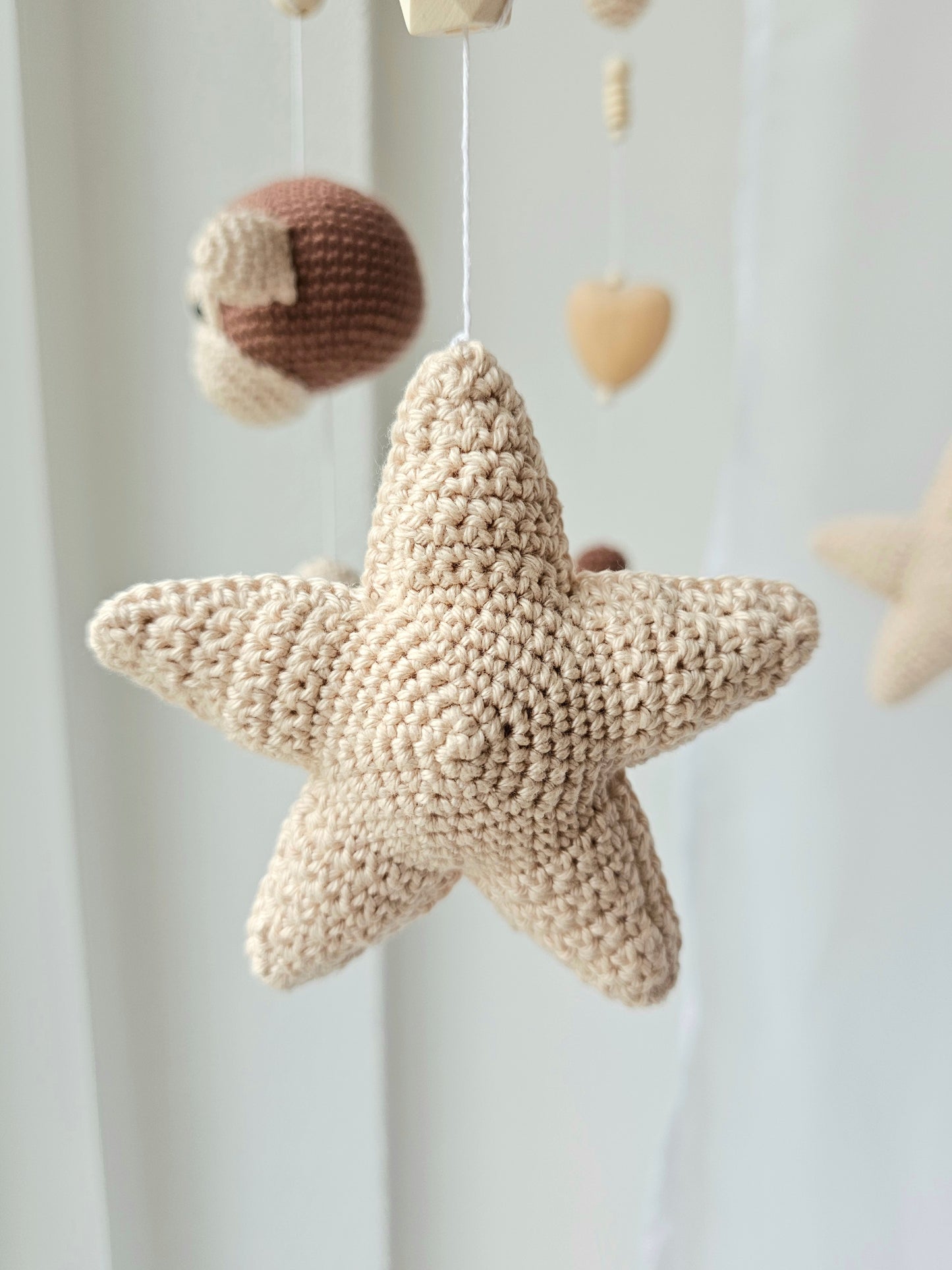 Selbstgemachtes Babymobile mit liebevoll von Hand gehäkelten Figuren und Formen, ideal für das Kinderbett oder den Kinderwagen. Hergestellt aus weichem, hochwertigem Filz in bunten Farben, fördert das Babymobile die visuelle und sensorische Entwicklung des Babys. Leicht und sicher aufzuhängen, schafft es eine beruhigende und kreative Umgebung für Ihr Kind.