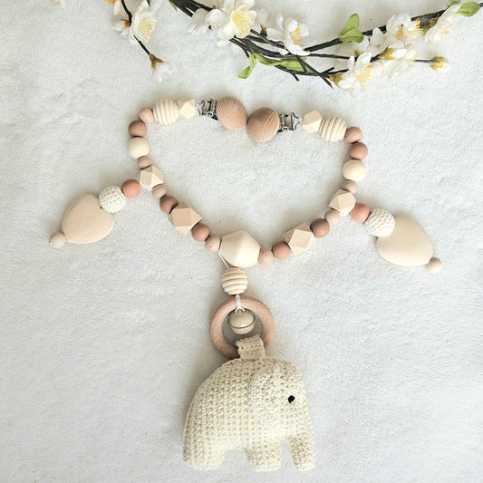 Eine handgefertigte Kinderwagenkette aus bunten Perlen und Häkelelementen. Die lebendigen Farben und unterschiedlichen Texturen bieten Ihrem Baby unterwegs Unterhaltung und fördern die Sinne. Ideal zur Befestigung am Kinderwagen.