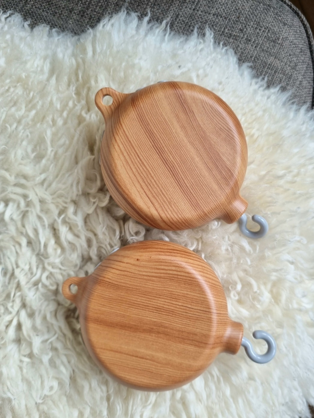 Mobile Spieluhr mit Oberfläche in Holzoptik, die beruhigende Melodien abspielt, ideal für das Kinderbett oder den Kinderwagen. Ausgestattet mit bunten Tierfiguren und sanften Bewegungen, fördert sie die visuelle und auditive Stimulation des Babys. Einfach zu befestigen und batteriebetrieben für eine unkomplizierte Nutzung. Perfekt, um Babys in den Schlaf zu wiegen und eine natürliche, beruhigende Umgebung zu schaffen.