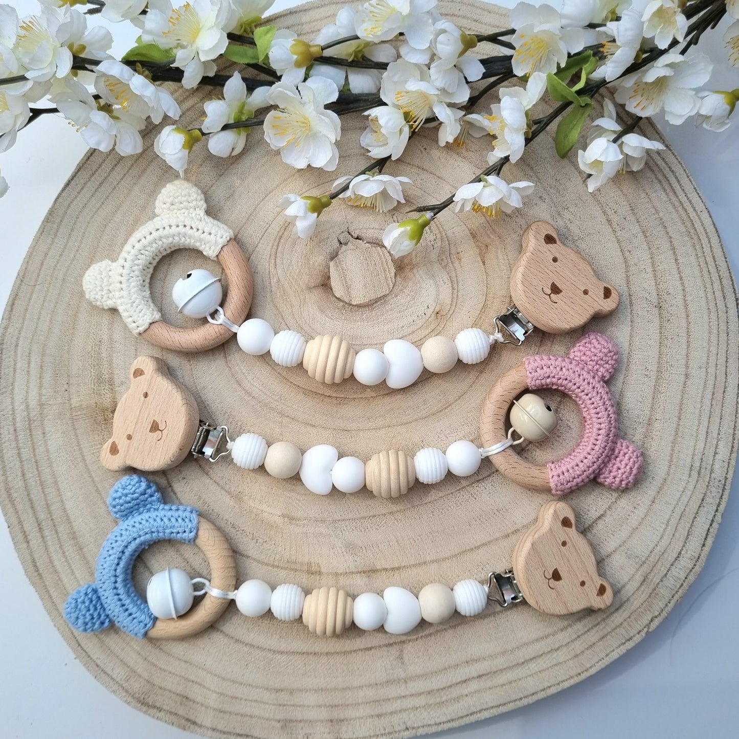 Ein handgefertigter Maxi-Cosi-Anhänger aus bunten Perlen, Holzelementen und Glocke, der unterwegs für Unterhaltung sorgt. Die verschiedenen Farben und Texturen machen das Reisen mit dem Baby nie langweilig. Ideal für Maxi-Cosi, Kinderwagen oder Bettchen.
