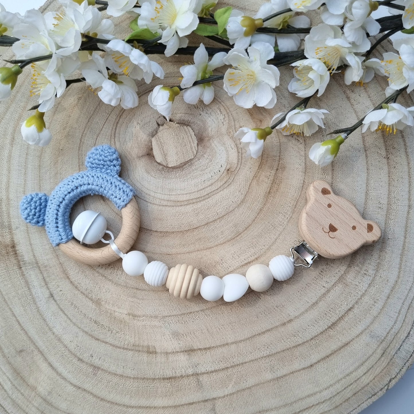 Ein handgefertigter Maxi-Cosi-Anhänger aus bunten Perlen und Holzelementen, der unterwegs für Unterhaltung sorgt. Die verschiedenen Farben und Texturen machen das Reisen mit dem Baby nie langweilig. Ideal für Maxi-Cosi, Kinderwagen oder Bettchen.