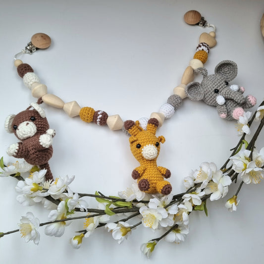 Eine handgefertigte Kinderwagenkette aus bunten Perlen und Häkelelementen. Die lebendigen Farben und unterschiedlichen Texturen bieten Ihrem Baby unterwegs Unterhaltung und fördern die Sinne. Ideal zur Befestigung am Kinderwagen.