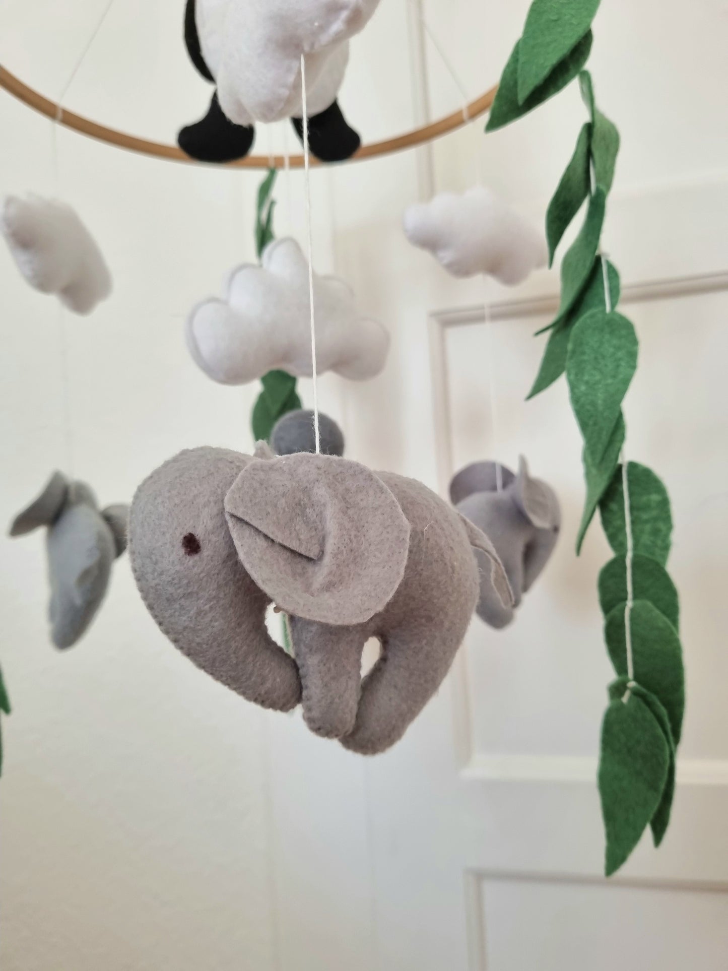 Selbstgemachtes Filzmobile mit liebevoll handgefertigten Figuren und Formen, ideal für das Babybett oder den Kinderwagen. Hergestellt aus weichem, hochwertigem Filz in bunten Farben, fördert es die visuelle und sensorische Entwicklung des Babys. Leicht und sicher aufzuhängen im Babyzimmer, schafft es eine beruhigende und kreative Umgebung für Ihr Kind.