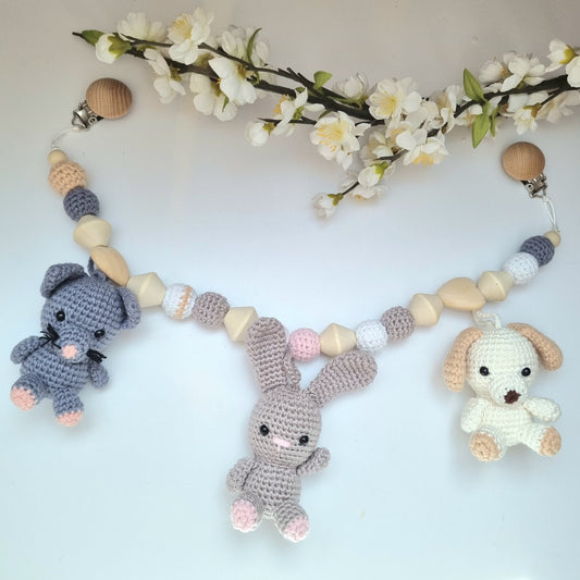 Eine handgefertigte Kinderwagenkette aus bunten Perlen und Häkelelementen. Die lebendigen Farben und unterschiedlichen Texturen bieten Ihrem Baby unterwegs Unterhaltung und fördern die Sinne. Ideal zur Befestigung am Kinderwagen.