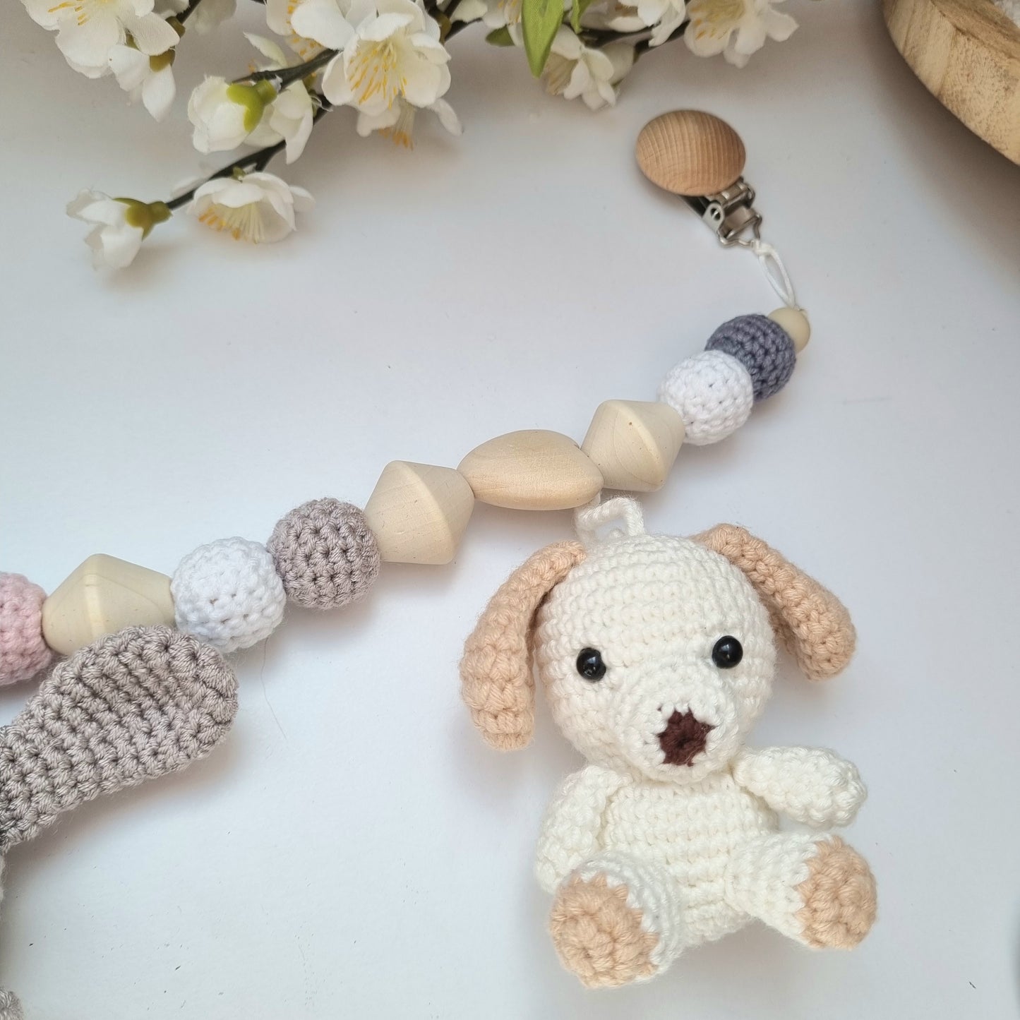 Eine handgefertigte Kinderwagenkette aus bunten Perlen und Häkelelementen. Die lebendigen Farben und unterschiedlichen Texturen bieten Ihrem Baby unterwegs Unterhaltung und fördern die Sinne. Ideal zur Befestigung am Kinderwagen.