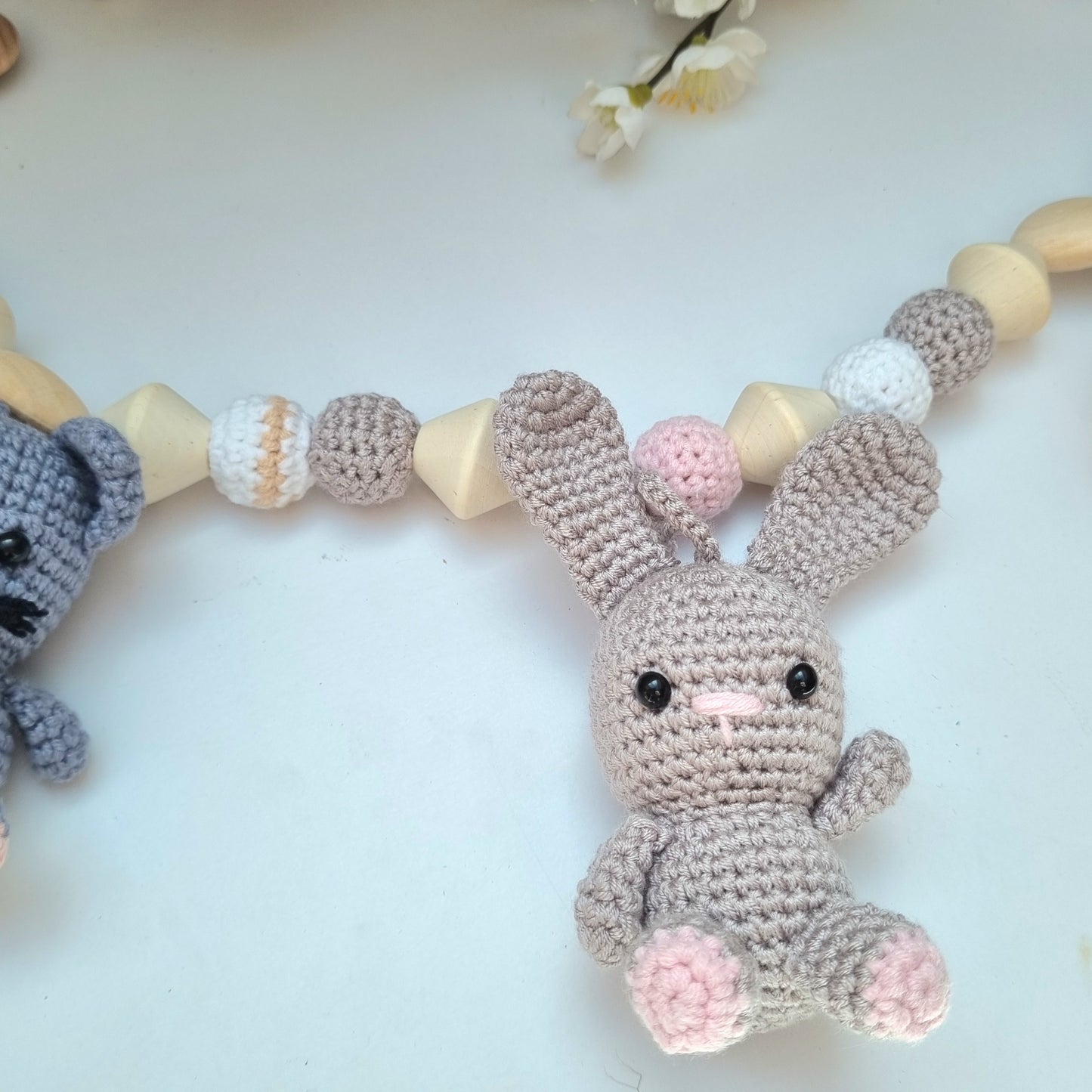 Eine handgefertigte Kinderwagenkette aus bunten Perlen und Häkelelementen. Die lebendigen Farben und unterschiedlichen Texturen bieten Ihrem Baby unterwegs Unterhaltung und fördern die Sinne. Ideal zur Befestigung am Kinderwagen.