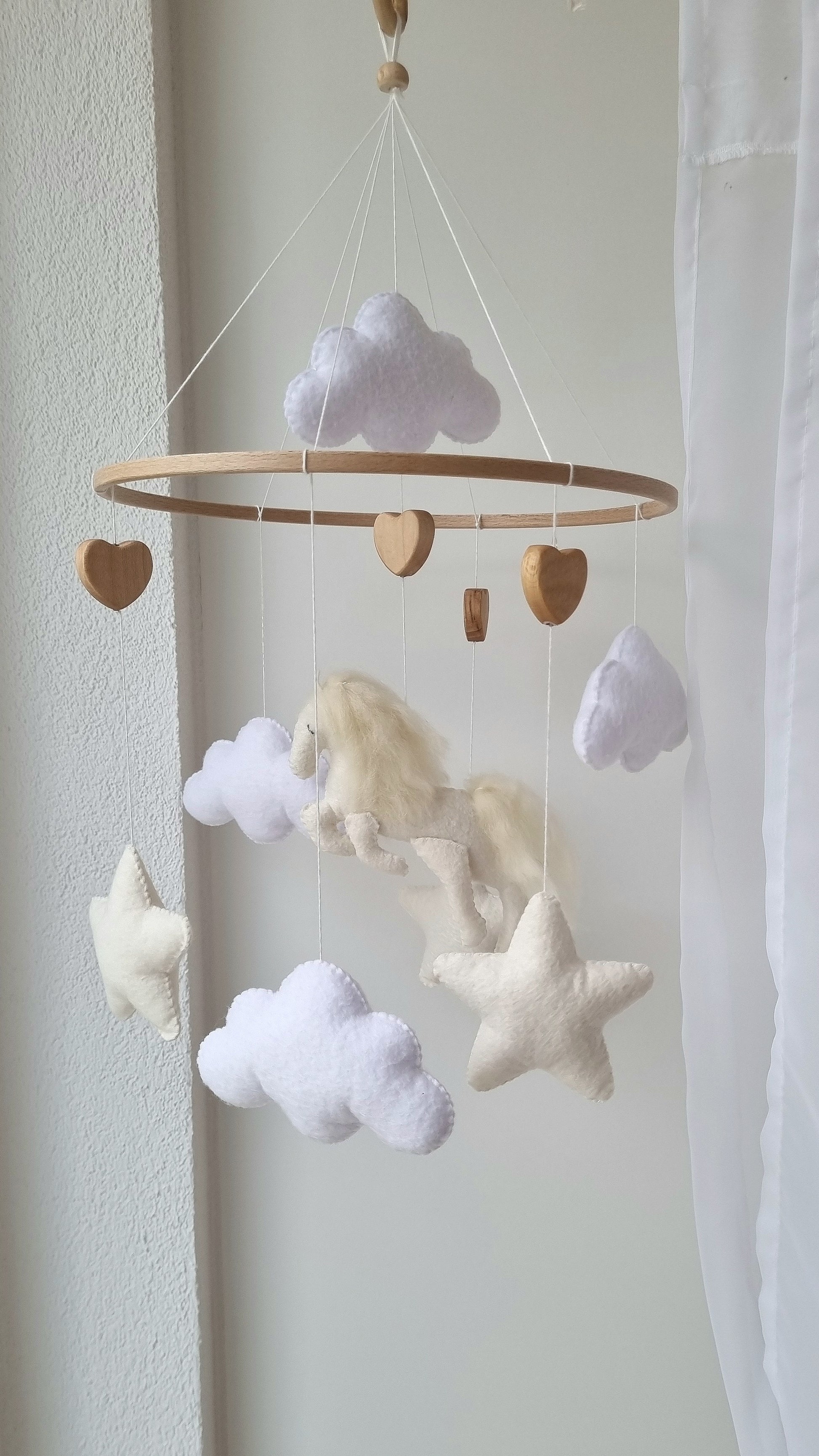 Selbstgemachtes Babymobile mit liebevoll handgefertigten Figuren und Formen, ideal für das Kinderbett oder den Kinderwagen. Hergestellt aus weichem, hochwertigem Filz in bunten Farben, fördert das Babymobile die visuelle und sensorische Entwicklung des Babys. Leicht und sicher aufzuhängen, schafft es eine beruhigende und kreative Umgebung für Ihr Kind.