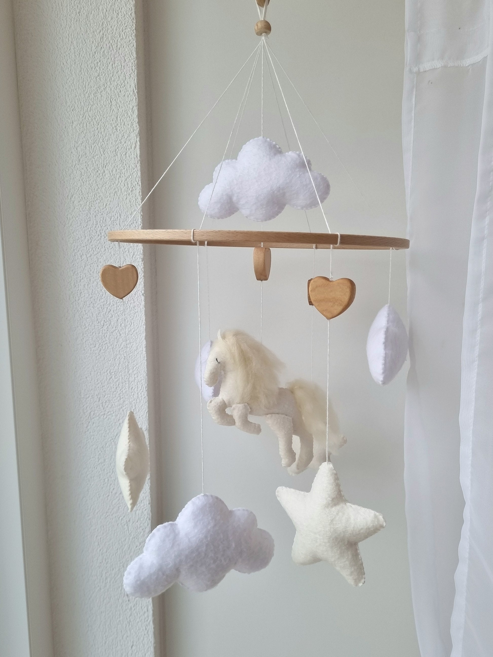 Selbstgemachtes Babymobile mit liebevoll handgefertigten Figuren und Formen, ideal für das Kinderbett oder den Kinderwagen. Hergestellt aus weichem, hochwertigem Filz in bunten Farben, fördert das Babymobile die visuelle und sensorische Entwicklung des Babys. Leicht und sicher aufzuhängen, schafft es eine beruhigende und kreative Umgebung für Ihr Kind.